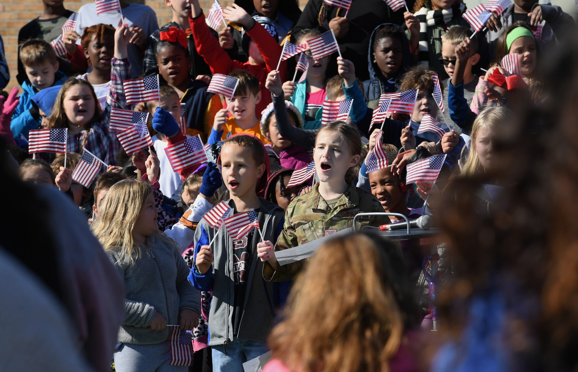 Students at Jeff Davis Elementary School sing patriotic songs during a Veterans Day celebration in Biloxi, Mississippi, Nov. 15, 2019. During the event, students also recited the Pledge of Allegiance. Keesler Air Force Base leadership and base personnel attended the event. (U.S. Air Force photo by Kemberly Groue)