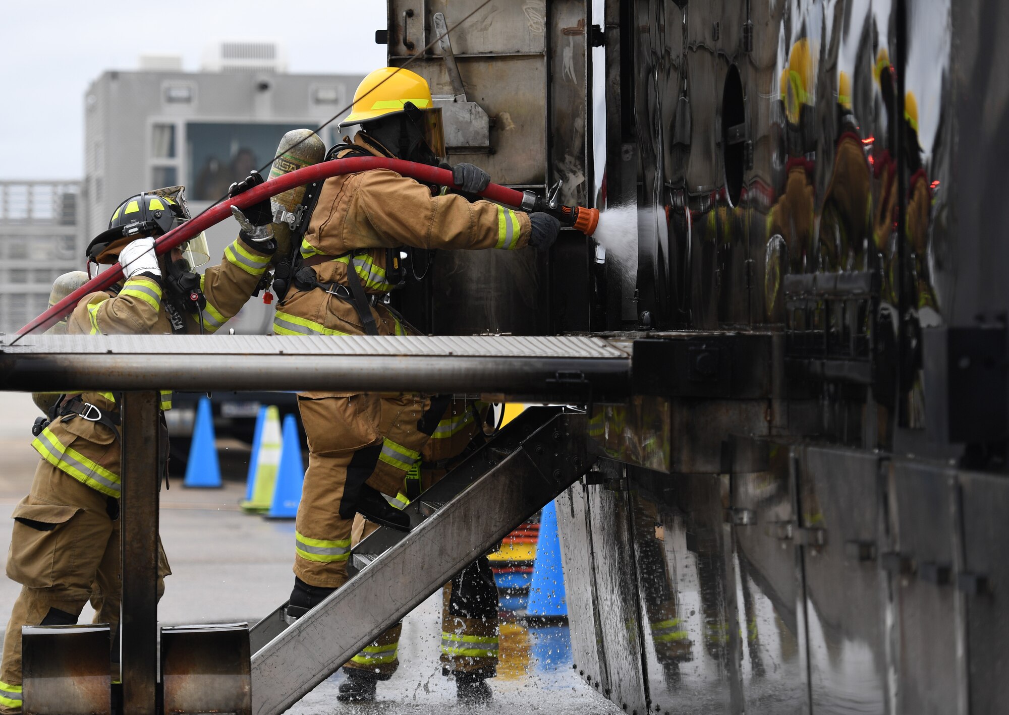 U.S. Air Force Airman Mason Songy, 209th Civil Engineer Squadron firefighter, Gulfport Combat Readiness Training Center Fire Department, Mississippi, and James Pettus, 81st Infrastructure Division firefighter, use a hand-held hose to extinguish a fire inside a mock C-123 training device during an aircraft rescue fire fighting training exercise at Keesler Air Force Base, Mississippi, Nov. 8, 2019. The five-day joint agency training allowed the Keesler Fire Department and the Gulfport Combat Readiness Training Center Fire Department to meet the semi-annual training requirement to practice aircraft rescue and live fire training evolutions. (U.S. Air Force photo by Kemberly Groue)