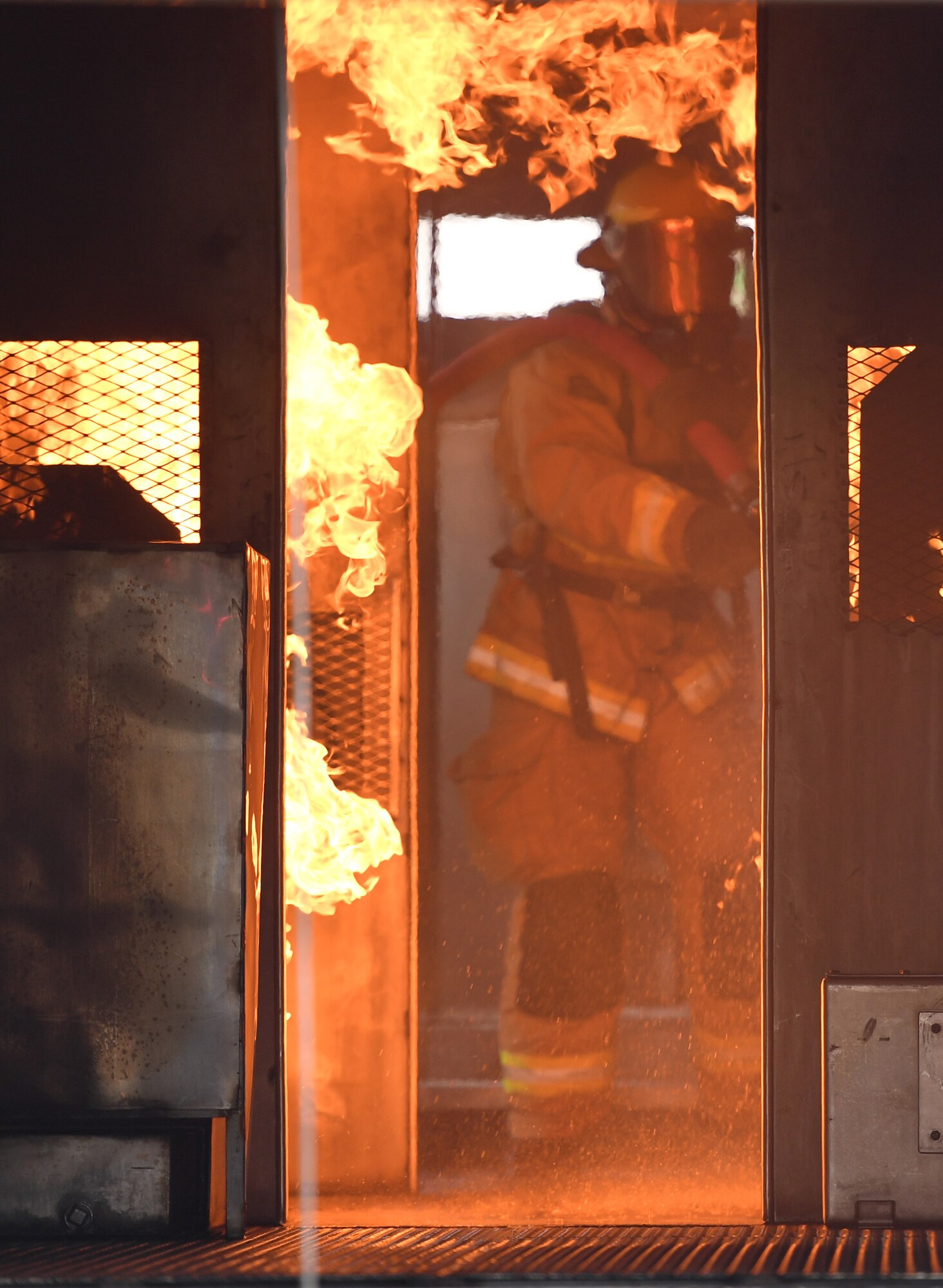 U.S. Air Force Airman Mason Songy, 209th Civil Engineer Squadron firefighter, Gulfport Combat Readiness Training Center Fire Department, Mississippi, uses a hand-held hose to extinguish a fire inside a mock C-123 training device during an aircraft rescue fire fighting training exercise at Keesler Air Force Base, Mississippi, Nov. 8, 2019. The five-day joint agency training allowed the Keesler Fire Department and the Gulfport Combat Readiness Training Center Fire Department to meet the semi-annual training requirement to practice aircraft rescue and live fire training evolutions. (U.S. Air Force photo by Kemberly Groue)