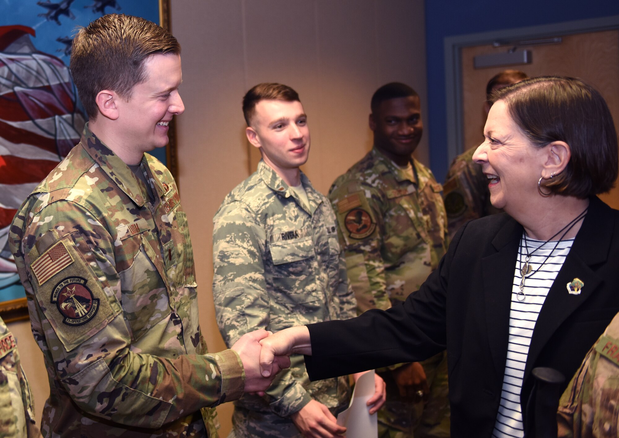 U.S. Air Force 2nd Lt. Kiefer Luth, 334th Training Squadron student, shakes hands with his mother, Tamera Luth, during an Airfield Operations Officer Course graduation inside the Dempsey Conference Room inside Cody Hall at Keesler Air Force Base, Mississippi, Nov. 8, 2019. Luth recently completed the course and graduated in the room dedicated to his grandfather, retired Col. Derrel Dempsey. The room was dedicated to Dempsey to honor his military accomplishments. (U.S. Air Force photo by Airman Seth Haddix)