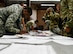 Airmen assigned to the 355th Wing recieve equipment for a simulated deployment during Exercise Bushwhacker 19-08 at Davis-Monthan Air Force Base, Arizona, Nov. 2, 2019. This exercise enabled the wing to rapidly deploy and execute the Dynamic Wing concept. (U.S. Air Force photo by 2nd Lt. Casey E. Bell)