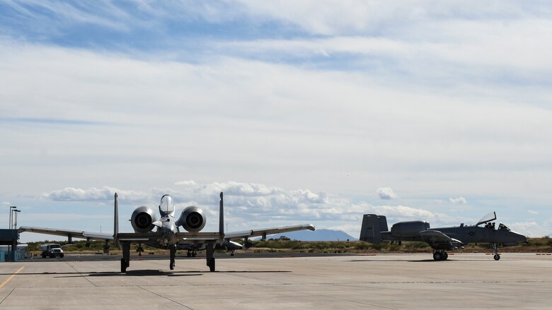 A photo of two A-10s taxiing on the runway.