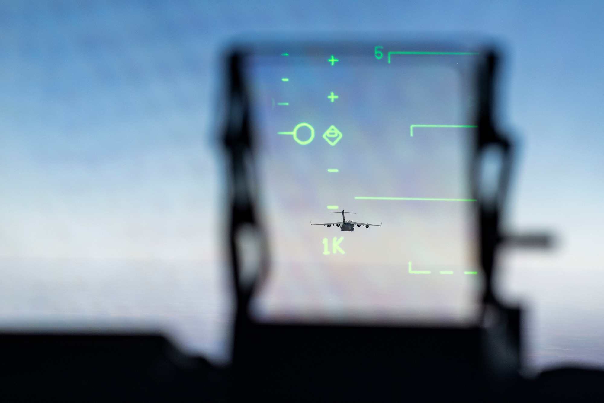 A C-17 Globemaster III is seen through the windshield of a second C-17