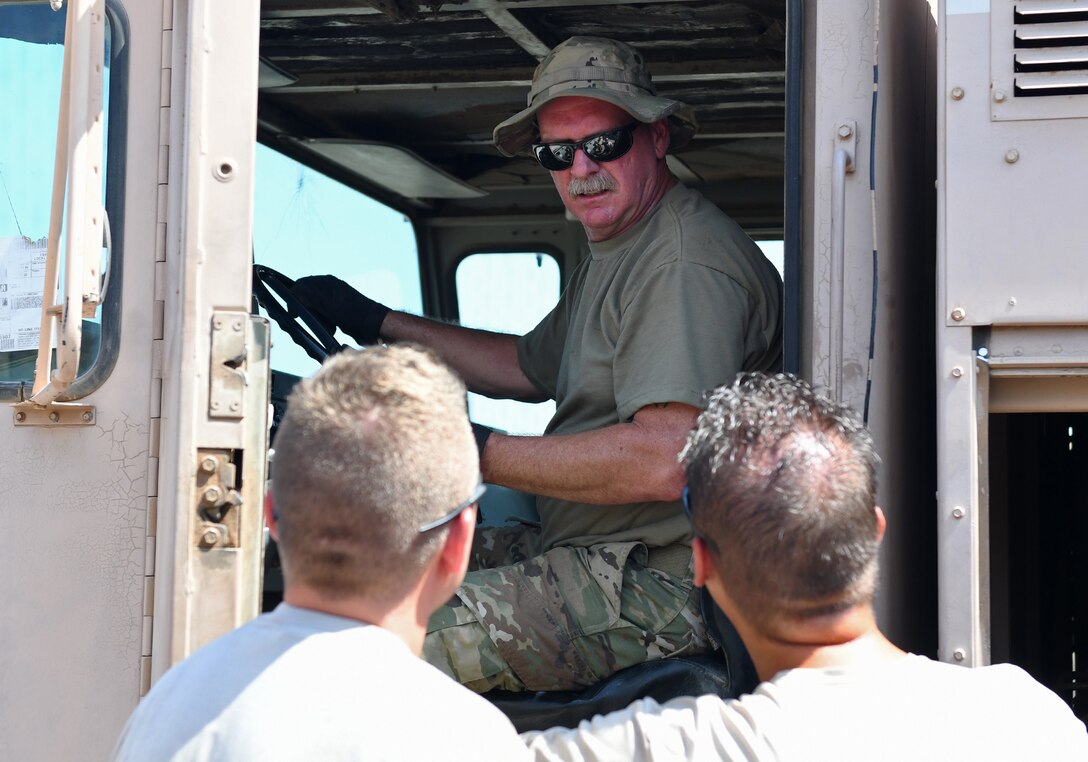 U.S. Air Force Master Sgt. Larry Davidson, top, 776th Expeditionary Air Base Squadron Fuels superintendent, talks to 726th EABS Vehicle Maintenance members during the meter calibration of an R11 refueling truck at Chabelley Airfield, Djibouti, Nov. 8, 2019. The 726th EABS Vehicle Maintenance team service and repair more than 140 Air Force vehicles in the Horn of Africa area of responsibility. (U.S. Air Force photo by Staff Sgt. Alex Fox Echols III)