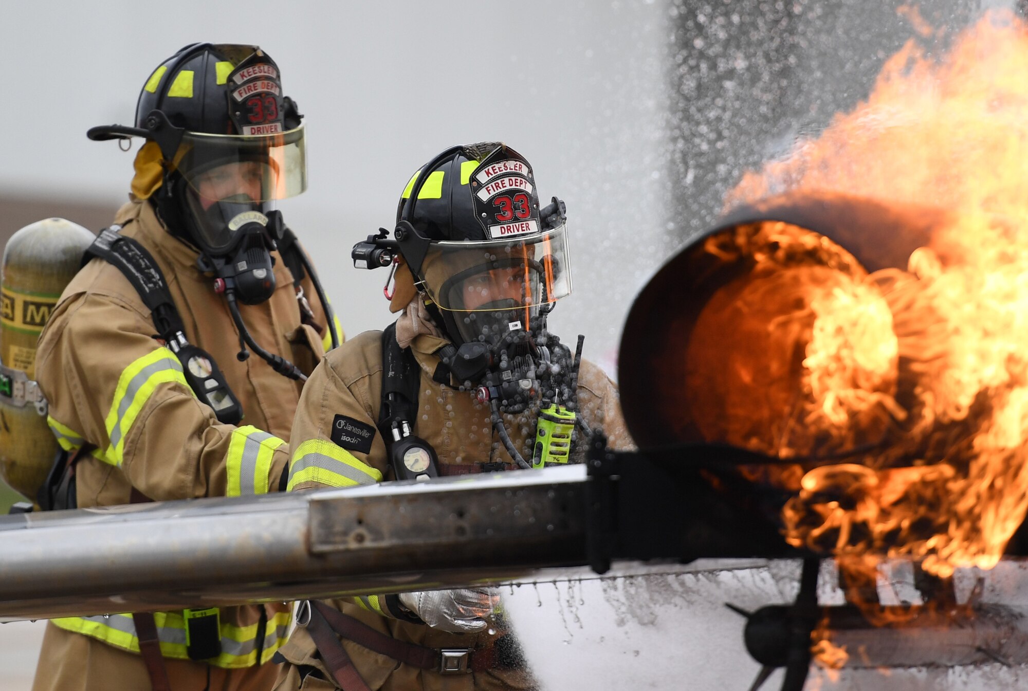 Cole Ballard and Seth Corn, 81st Infrastructure Division firefighters, use a hand-held hose to extinguish a fire on a mock C-123 training device during an aircraft rescue fire fighting training exercise at Keesler Air Force Base, Mississippi, Nov. 8, 2019. The five-day joint agency training allowed the Keesler Fire Department and the Gulfport Combat Readiness Training Center Fire Department to meet the semi-annual training requirement to practice aircraft rescue and live fire training evolutions. (U.S. Air Force photo by Kemberly Groue)