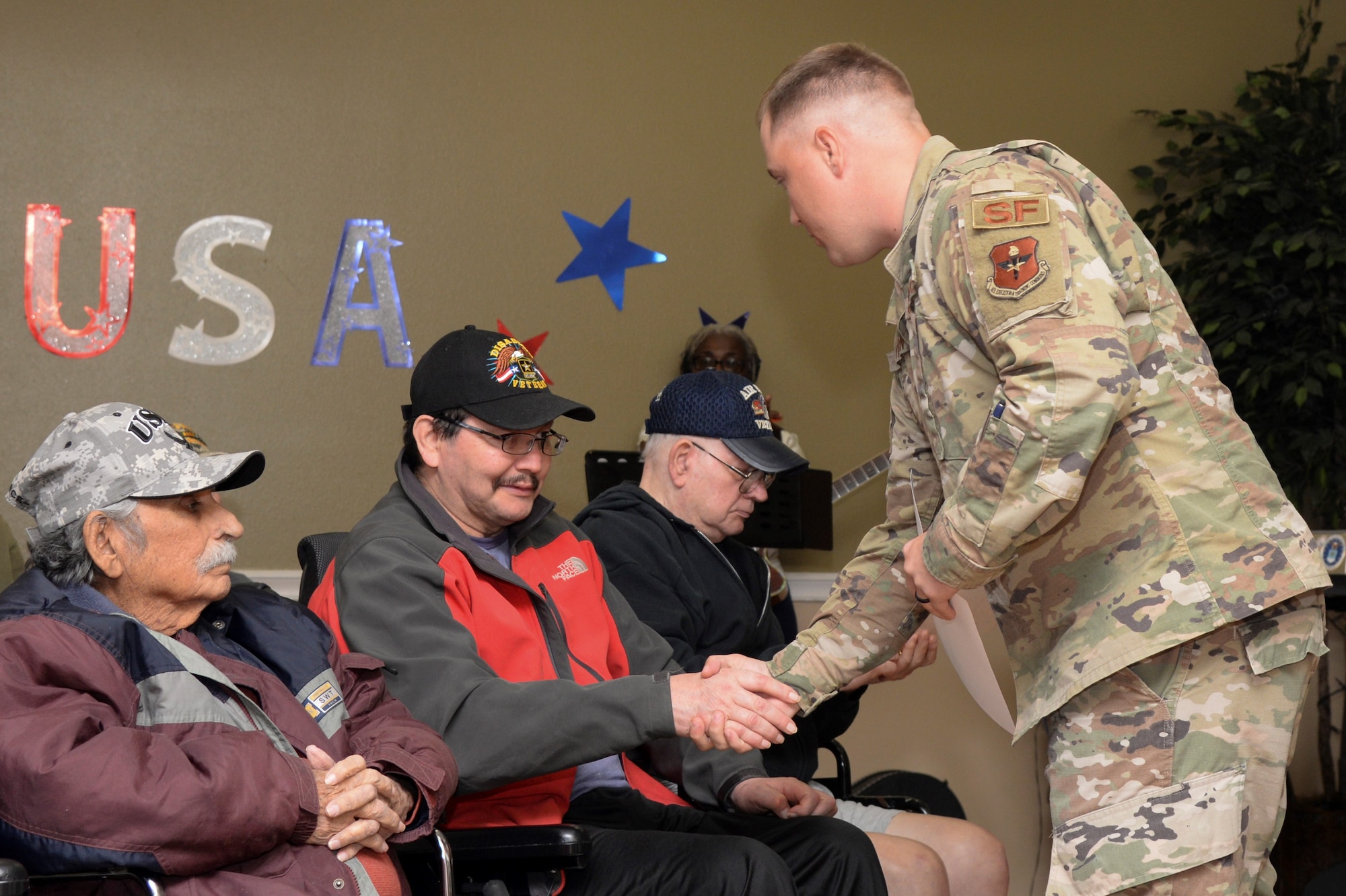 Staff Sgt. Bradley Rayburn, 343rd Training Squadron Block One Instructor, shakes the hand of a veteran as he distributes certificates during a Veterans Day ceremony at Legend Oaks Healthcare and Rehabilitation in San Antonio Nov. 8.