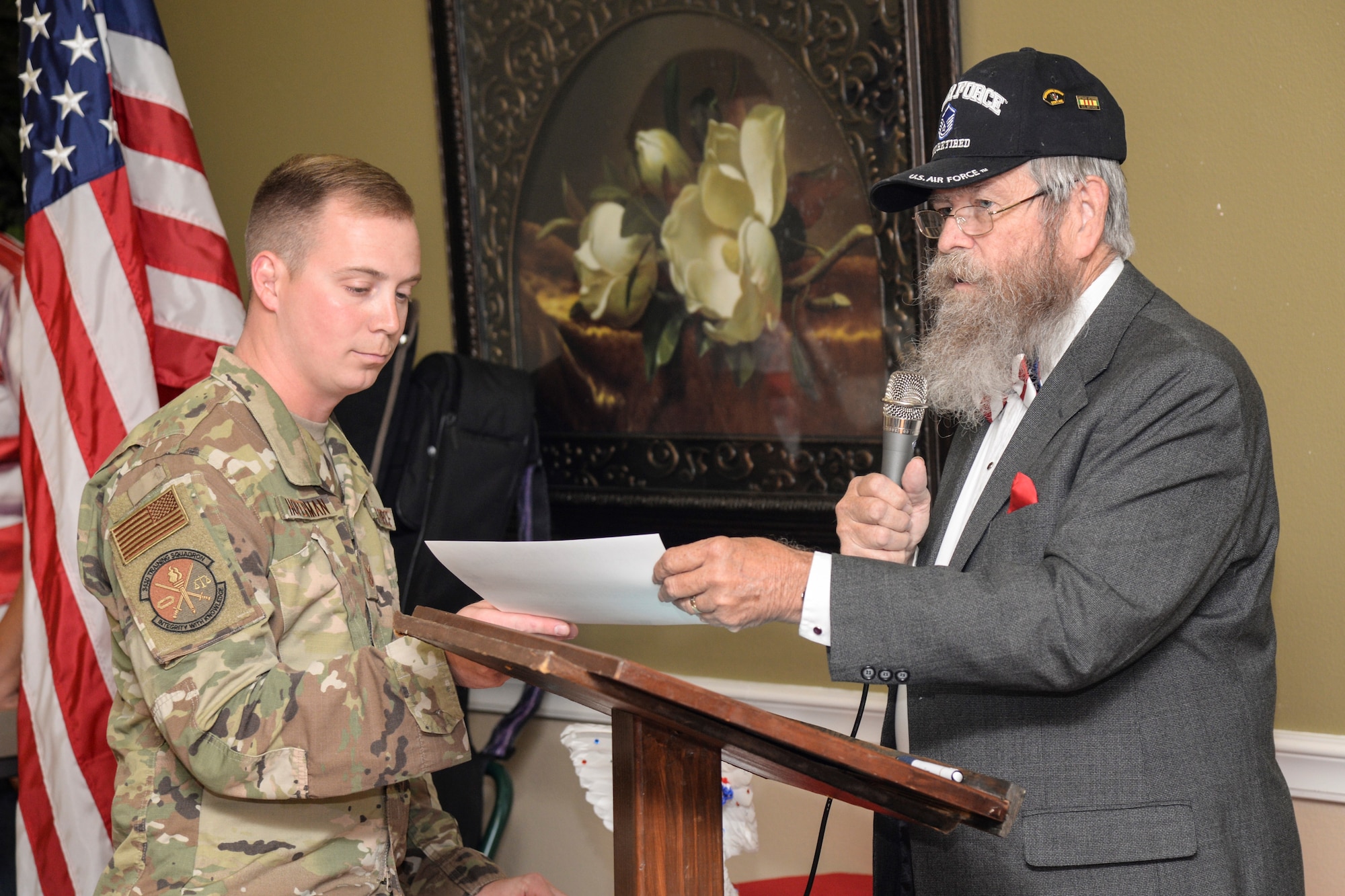 Chaplain Albert Owens, the event emcee, gives Tech. Sgt. Caleb Hoferman, 343rd Training Squadron Block One Instructor, a certificate to present to a veteran at a Veterans Day ceremony at Legend Oaks Healthcare and Rehabilitation in San Antonio Nov. 8.