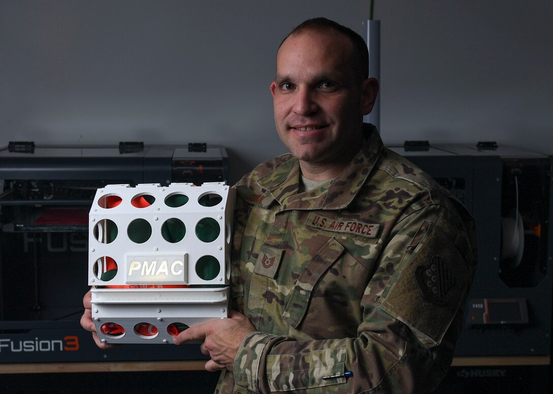 U.S. Air Force Tech. Sgt. Daniel Caban, 1st Aircraft Maintenance Squadron crew chief, poses with his Portable Magnetic Aircraft Covers prototype in the 1st Fighter Wing Innovation Cell Lab at Joint Base Langley-Eustis, Virginia, Nov. 5, 2019.