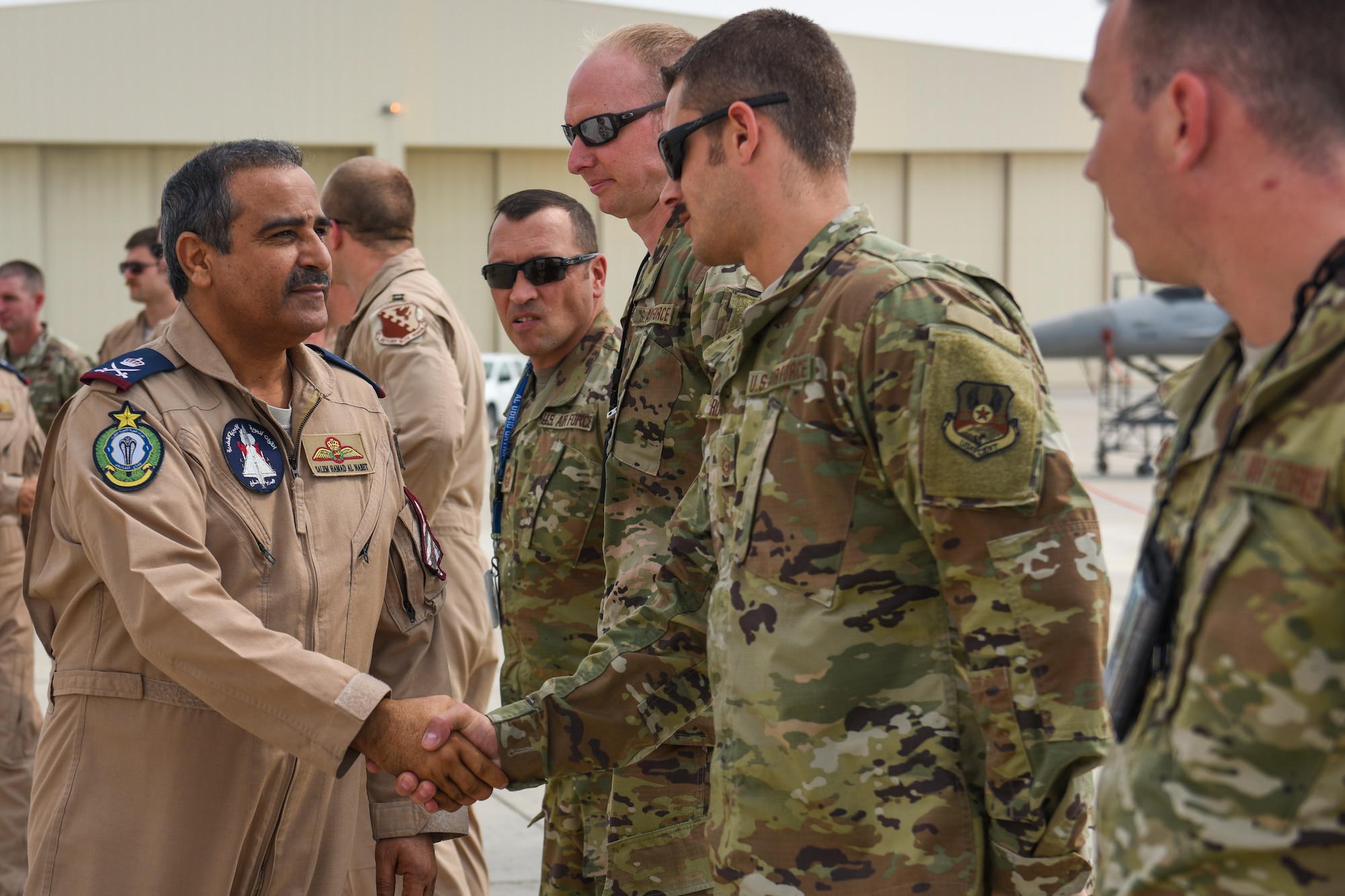 The Commander of the Qatar Emiri Air Force, Staff MG Pilot Salem Bin Hamad Al-Nabet, shakes hands with U.S. Airmen during a visit to Al Udeid Air Base Qatar, Nov 10, 2019.