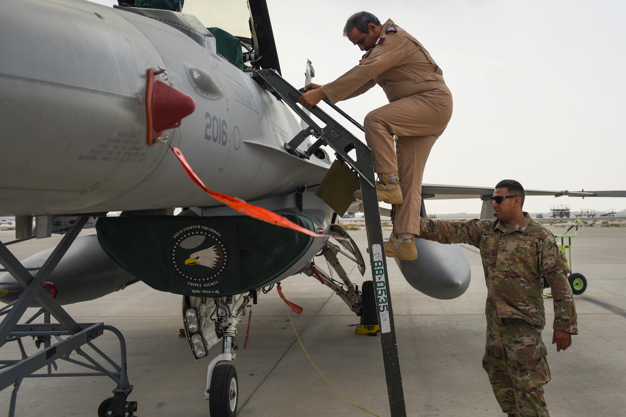 The Commander of the Qatar Emiri Air Force, Staff MG Pilot Salem Bin Hamad Al-Nabet, climbs into a U.S. Air Force F-16 Fighting Falcon during a visit to Al Udeid Air Base Qatar, Nov 10, 2019.