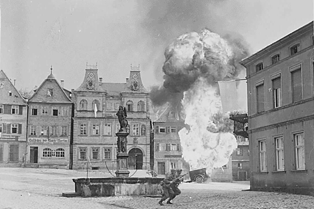 A European city is bombed.  Soldiers run near a statue in the center.