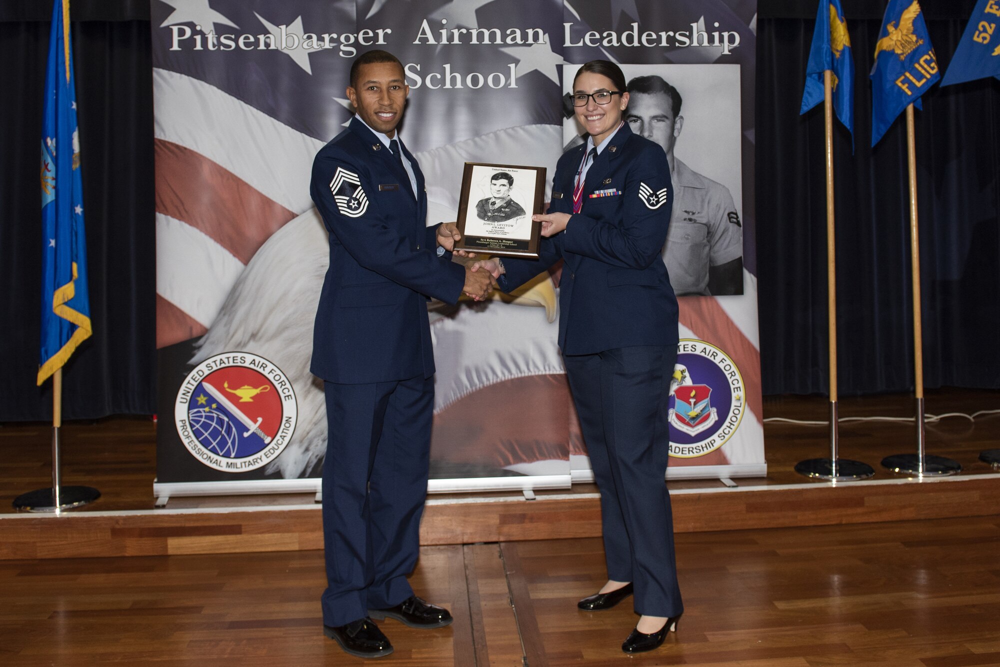 U.S. Air Force Chief Master Sgt. Willie Houser, 52nd Maintenance Squadron wing propulsion system manager, presents Staff Sgt. Rebecca Hooper with the John Levitow award at Spangdahlem Air Base, Germany, Nov. 15, 2019. The John Levitow award is the highest award given to an Airman Leadership School graduate. (U.S. Air Force photo by Airman 1st Class Alison Stewart)