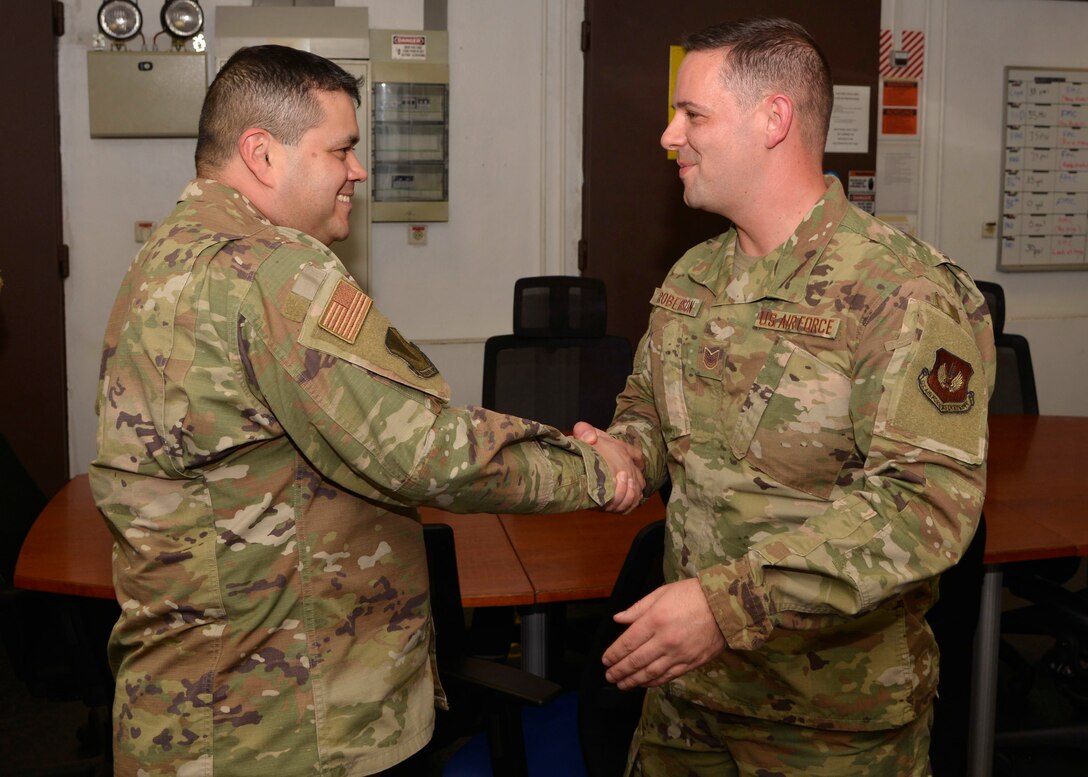 U.S. Air Force Chief Master Sgt. Ernesto J. Rendon, 86th Airlift Wing command chief, congratulates Tech. Sgt. Kendal “Wade” Roberson, 86th Maintenance Squadron hydraulic section chief, for being named Airlifter of the Week at Ramstein Air Base, Germany, Nov. 5, 2019.