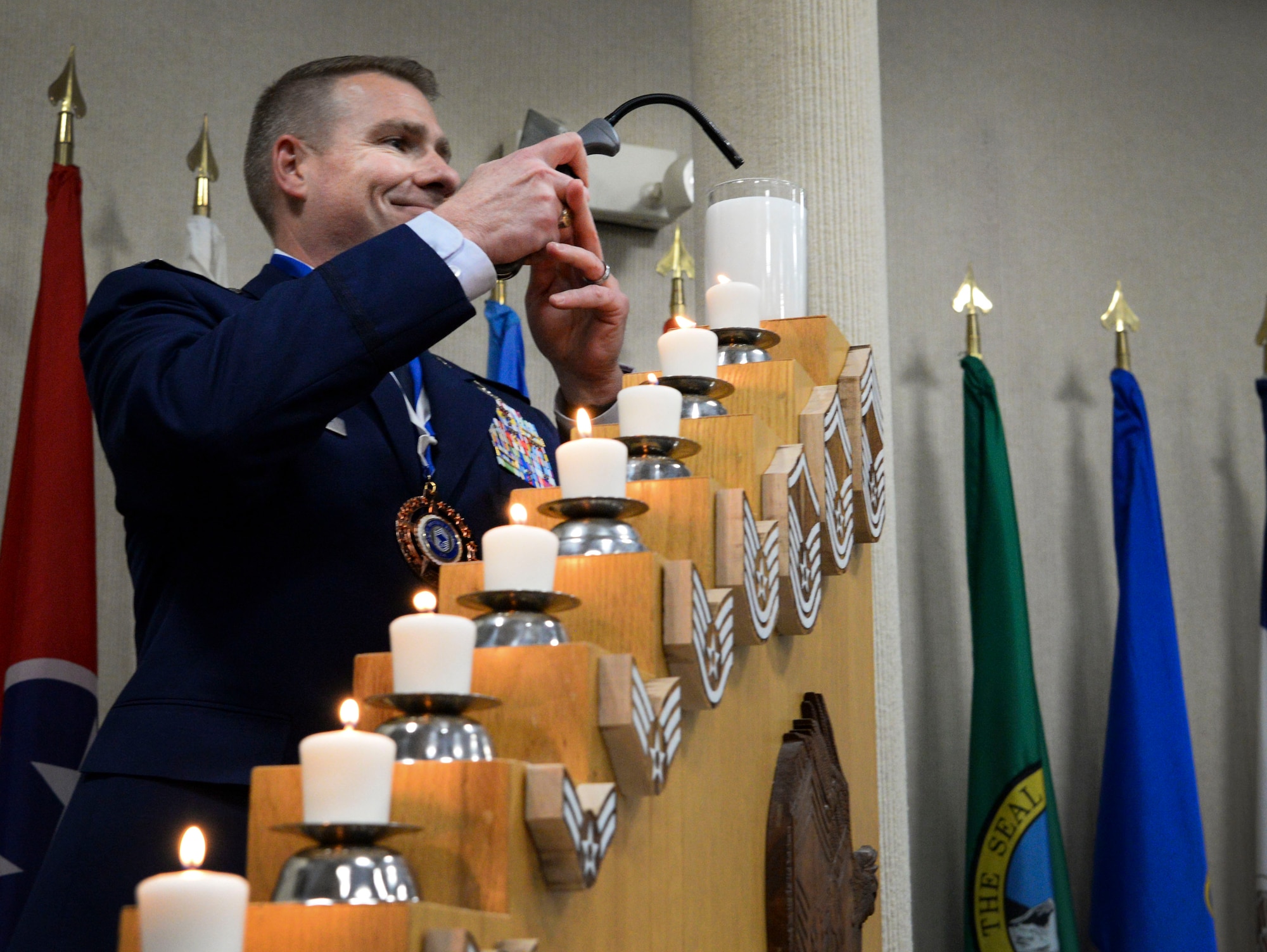 Col. Chad Ellsworth, 66th Air Base Group and installation commander, lights the chief’s candle during his honorary chief induction ceremony at Hanscom Air Force Base, Mass., Nov. 15. The tradition of the candle lighting signifies the path of enlisted ranks from Airman Basic, E-1, to Chief Master Sgt., E-9. (U.S. Air Force photo by Lauren Russell)