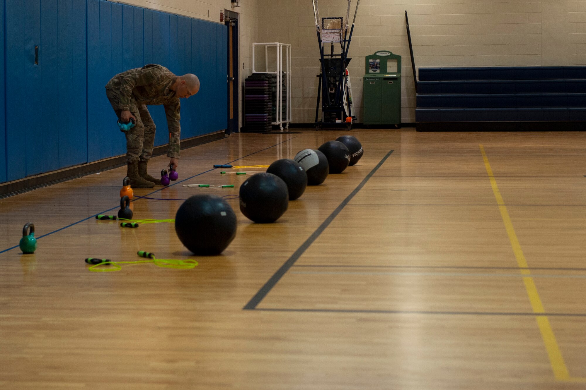 A photo of an Airman setting up kettlebells for Family Boot Camp