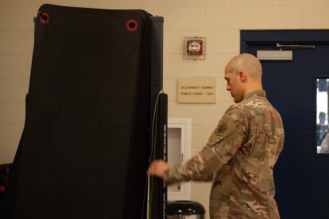 A photo of an Airman putting jump ropes away after Family Boot Camp