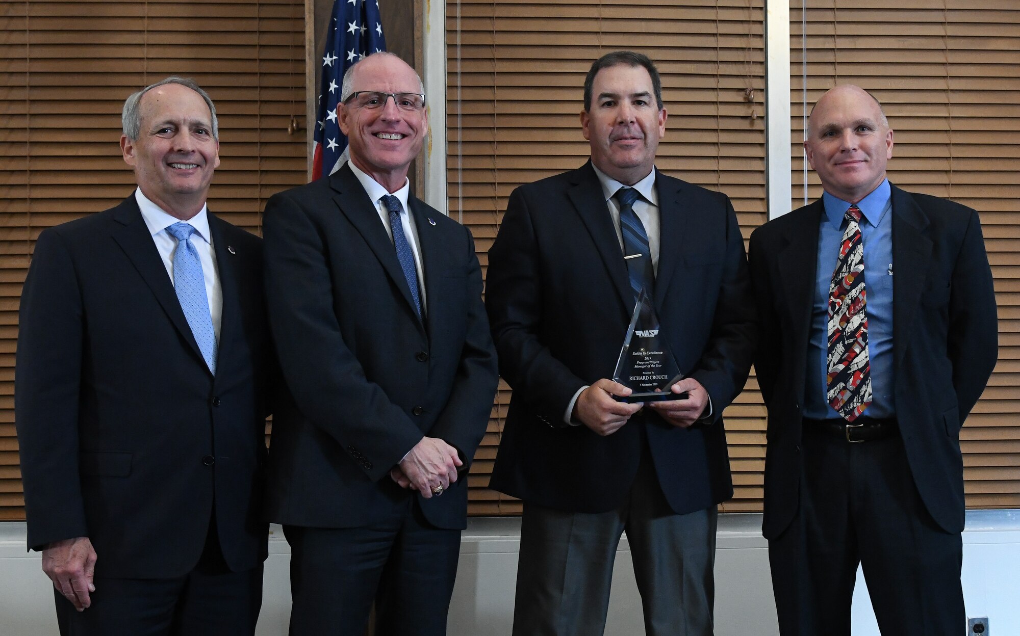 Capital Projects Manager Richard Crouch, third from the left, receives the Program/Project Manager of the Year award during the National Aerospace Solutions (NAS), LLC, Salute to Excellence Annual Awards Banquet, Nov. 5, 2019, at the Arnold Lakeside Center, Arnold Air Force Base, Tenn. Also pictured, from left, is NAS Deputy General Manager Michael Belzil, NAS General Manager Dr. Richard Tighe and NAS Base Operations and Support Director Ronnie Skipworth. (U.S. Air Force photo by Jill Pickett)