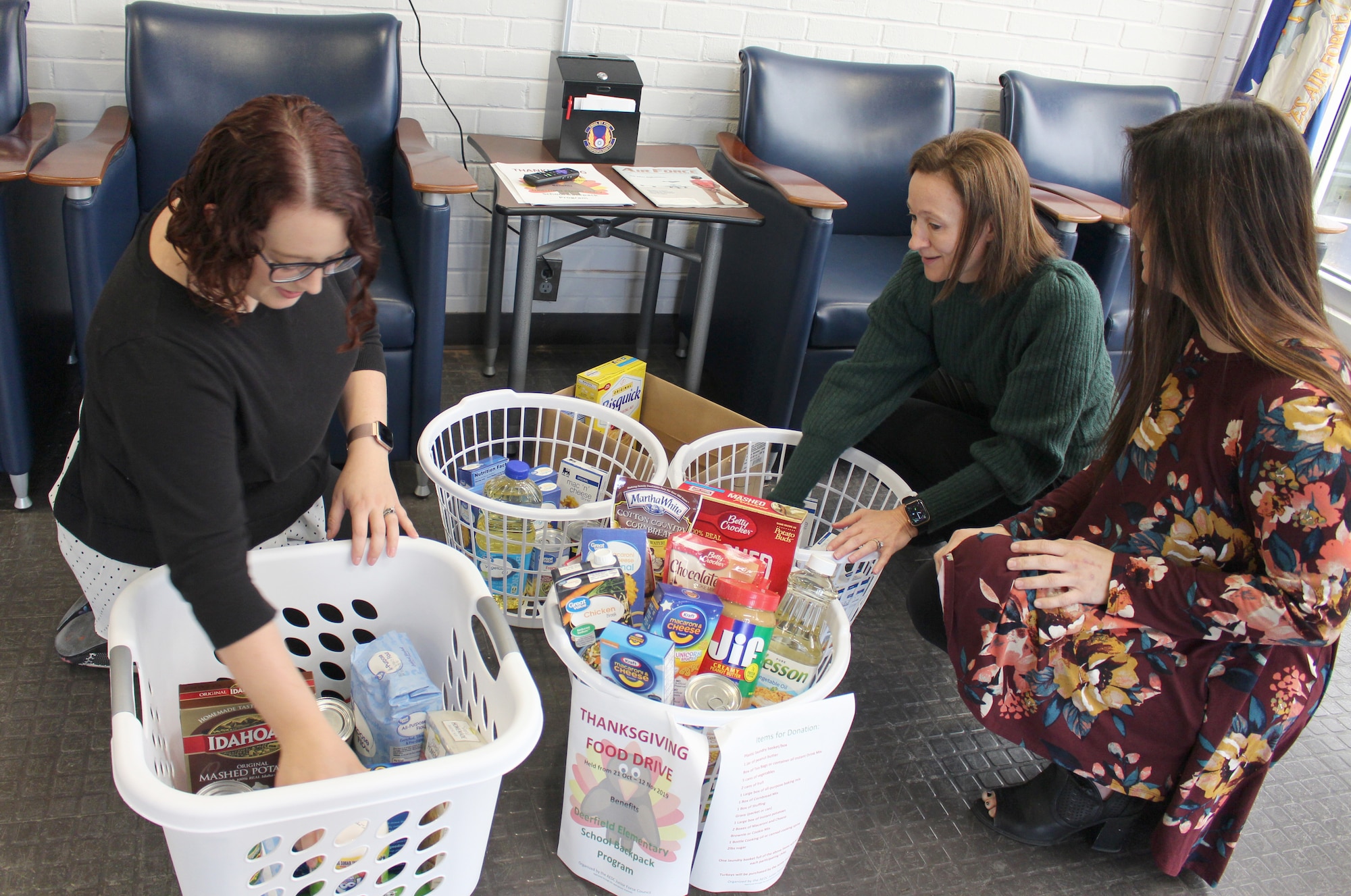 Junior Force Council members Rachel Garrard, Angela Bowden and Leah Lasater pack baskets with food items donated as part of the Thanksgiving Food Basket Program at Arnold Air Force Base. Arnold JFC members collected enough items for more than 30 food baskets for Coffee County families in need of Thanksgiving meals. (U.S. Air Force photo by Deidre Moon)