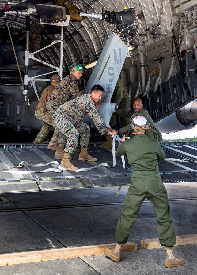 U.S. service members with Marine Light Attack Helicopter Squadron 369, 3rd Marine Aircraft Wing (MAW) unload a U.S. Marine Corps AH-1Z Cobra from a U.S. Air Force C-17 Globemaster III at Marine Corps Air Station Futenma in Okinawa, Japan, Nov. 11, 2019. The C-17 delivered the cobra as part of a MAW semi-annual aircraft swap within the unit deployment program. (U.S. Marine Corps photo by Cpl. Savannah Mesimer)