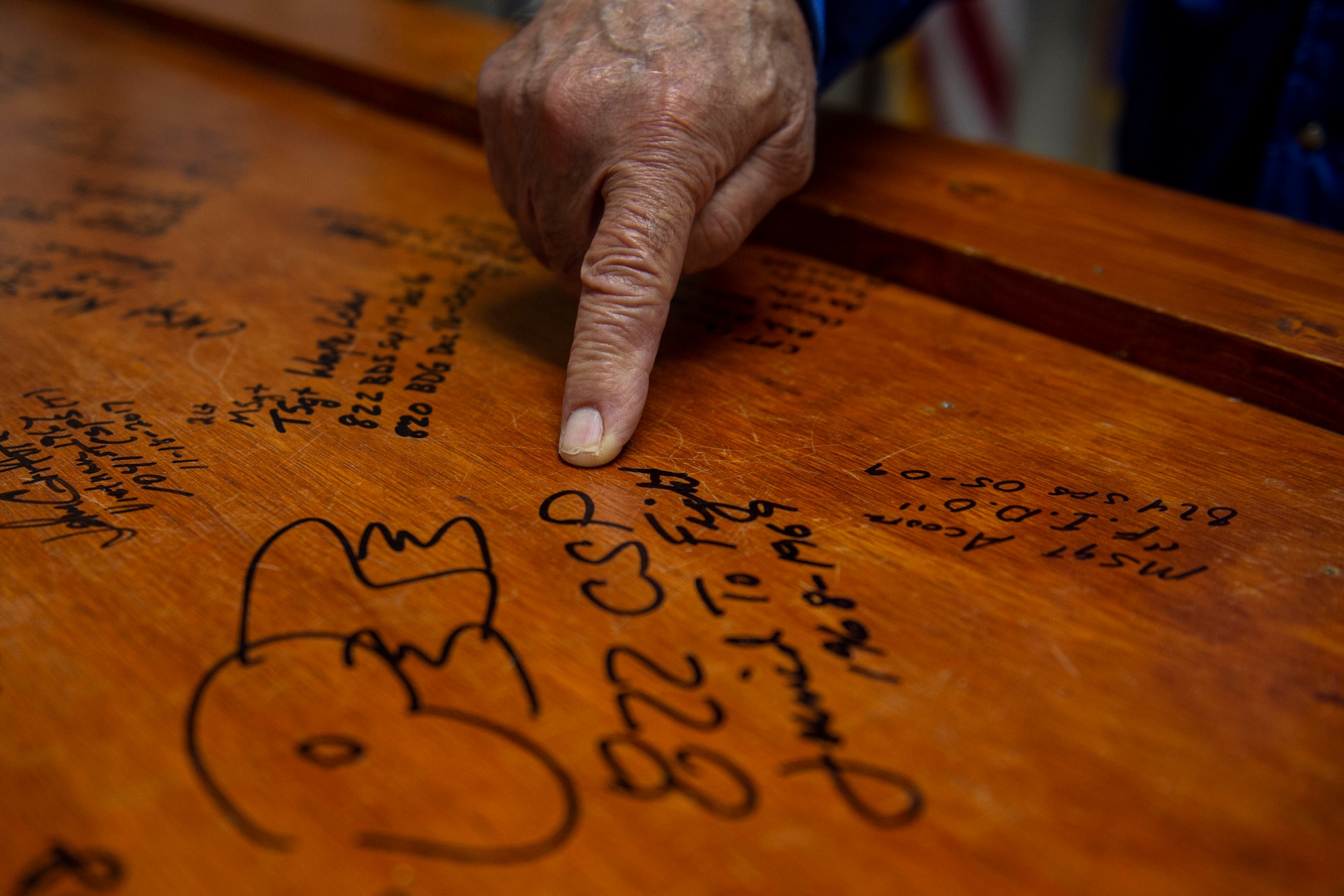 A Safeside Association member points to his signature on a commemorative table Nov. 8, 2019, at Moody Air Force Base, Ga. Safeside members come together every two years to participate in a three-day event to expose new 820th Base Defense Group Airmen to their heritage. The reunion consists of a memorial service for fallen Safeside members, current capabilities demonstration and golf tournament. (U.S. Air Force photo by Airman Azaria E. Foster)