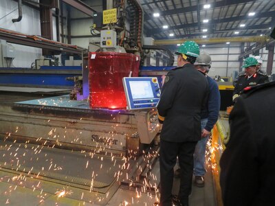 Royal Saudi Naval Forces Eastern Fleet Commander Admiral Fahad Al-Shimrami views MMSC steel cutting in progress at FMM as sparks fly.