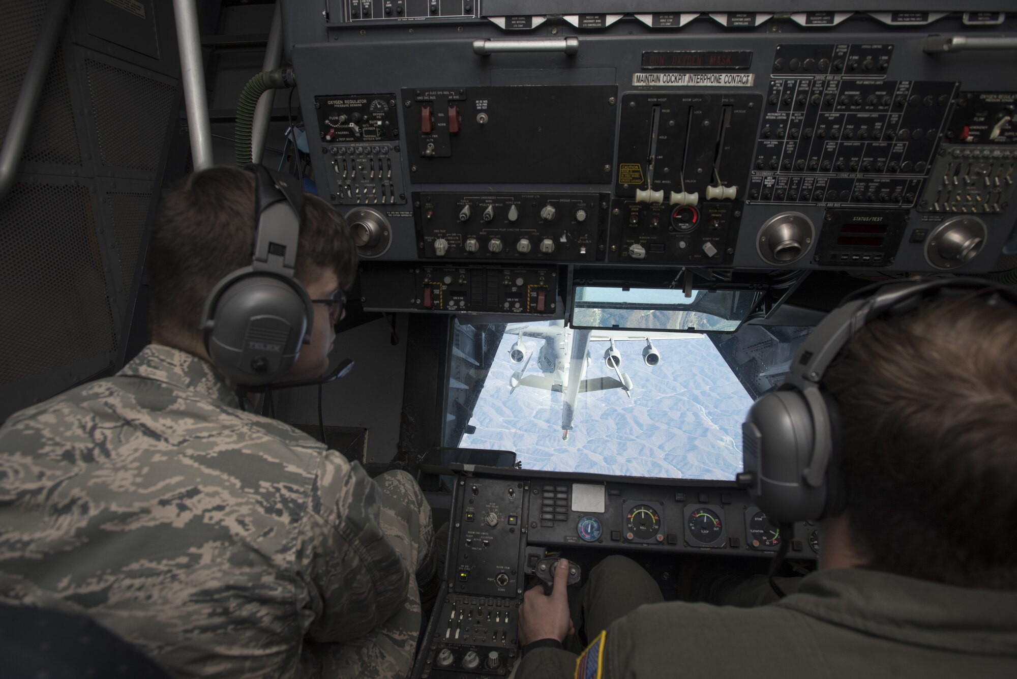 Cadet Second Class Alexander Cooper, 23rd Cadet Squadron support NCO assigned to the U.S. Air Force Academy, watches Senior Airman August Bueltmann, 2nd Air Refueling Squadron boom operator, refuel a C-17 Globemaster III on a flight headed to Colorado over the Midwest region of the United States, Nov. 17, 2019. The cadets toured their sponsoring wing, the 305th Air Mobility Wing, and were shown different job opportunities offered once they graduate. Cooper watched how a boom operator connects the KC-10 Extender to the C-17 below and refuels it in-flight. (U.S. Air Force photo by Airman 1st Class Ariel Owings)