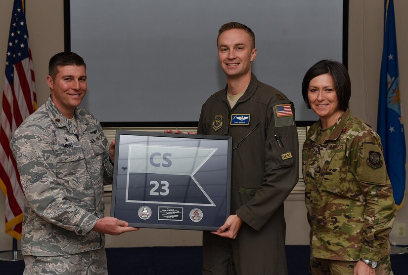 Maj. Daniel Moore, 23rd Cadet Squadron commanding air officer, gifts a framed 23rd CS flag to Maj. Chase Bradley, 305th Air Mobility Wing chief of Commanders Action Group, and Col. Jacqueline Breeden, 305th AMW commander for putting together a visit for the cadets on Joint Base McGuire-Dix-Lakehurst, New Jersey, Nov. 17, 2019. The 305th AMW sponsors the squadron and hosts the cadets approximately every other year for education on how the enlisted force contributes to Air Force operations and what opportunities are available to the cadets after they graduate. “The Wing really rolled out all the stops for us,” said Moore. “It was so well planned, everyone we met was so professional, so sharp and each embodied the ‘Can Do’ attitude. We couldn’t be more grateful. I think, for myself and the cadets, we walked away with a better understanding of the Wing, the mission and the Airmen.” (U.S. Air Force photo by Airman 1st Class Ariel Owings)
