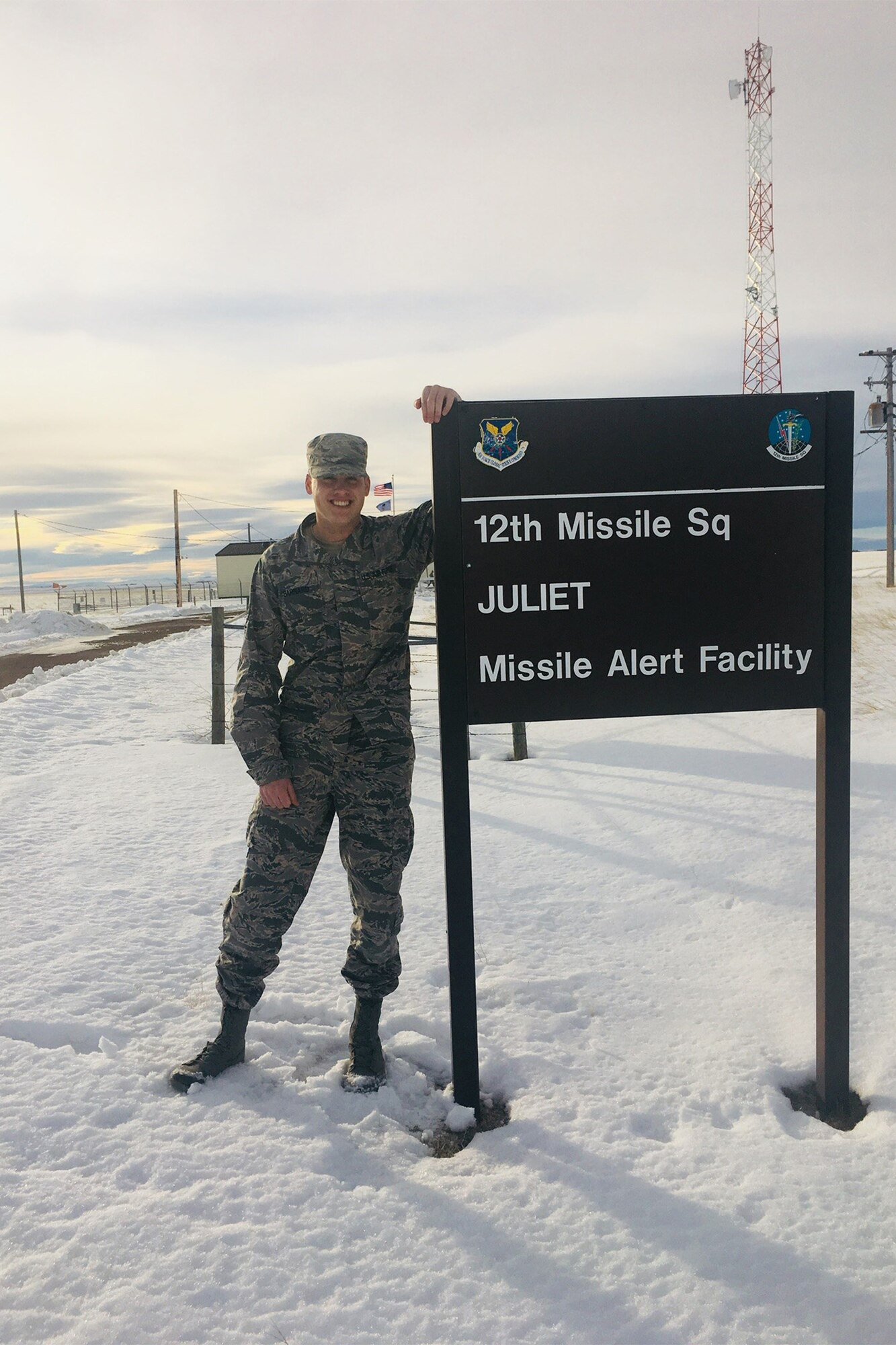 Then Staff Sgt. Clay Barnard, formerly a 12th Missile Squadron missile alert facility manager, poses for a picture by a sign at Juliet missile alert facility near Malmstrom Air Force Base, Mont.