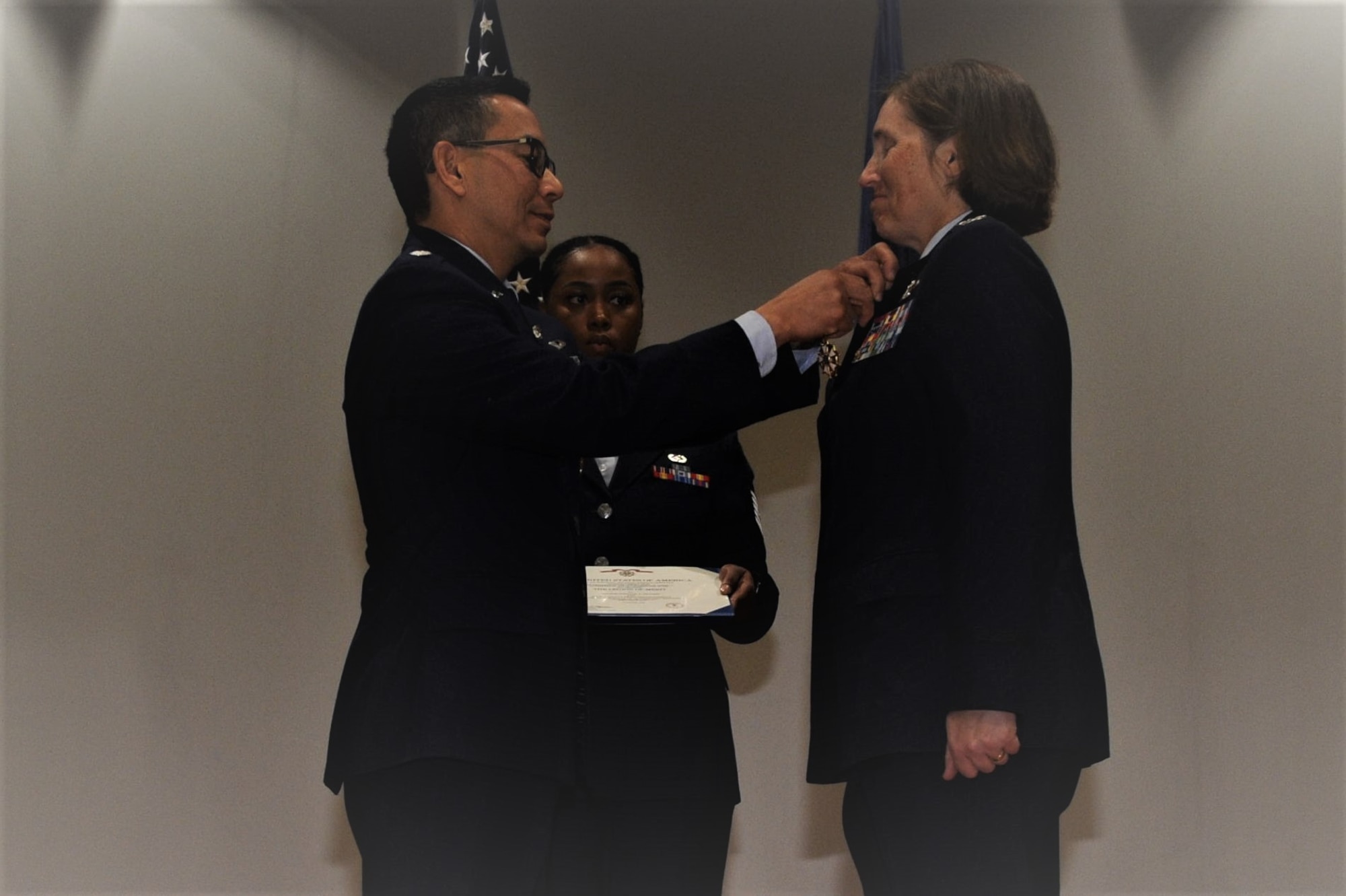 Stage shot of Col. Williams receiving retirement pin.