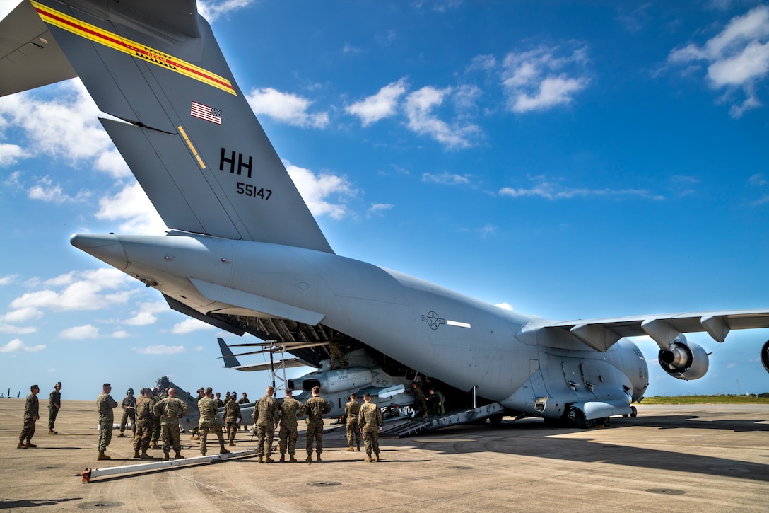 U.S. service members with Marine Light Attack Helicopter Squadron 369, 3rd Marine Aircraft Wing (MAW) unload a U.S. Marine Corps AH-1Z Cobra from a U.S. Air Force C-17 Globemaster III at Marine Corps Air Station Futenma in Okinawa, Japan, Nov. 11, 2019. The C-17 delivered the cobra as part of a MAW semi-annual aircraft swap within the unit deployment program. (U.S. Marine Corps photo by Cpl. Savannah Mesimer)