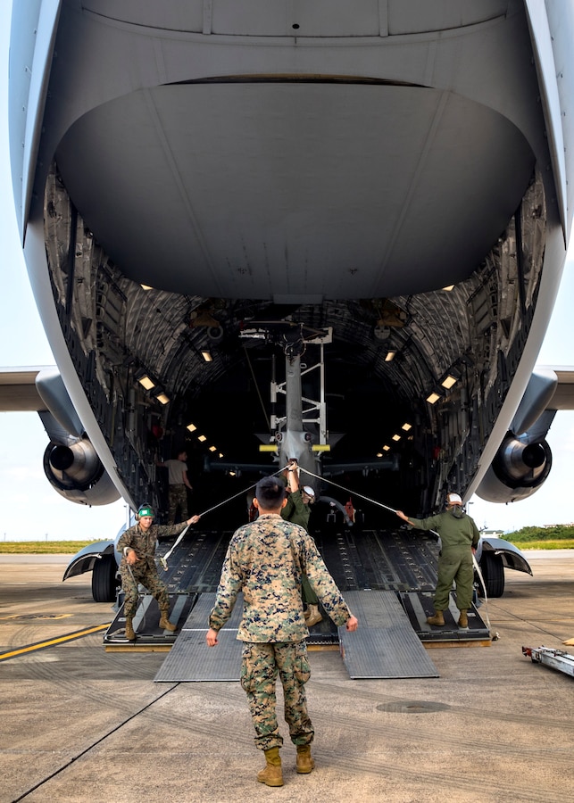 U.S. service members with Marine Light Attack Helicopter Squadron 369, 3rd Marine Aircraft Wing (MAW) unload a U.S. Marine Corps AH-1Z Cobra from a U.S. Air Force C-17 Globemaster III at Marine Corps Air Station Futenma in Okinawa, Japan, Nov. 11, 2019. The C-17 delivered the cobra as part of a MAW semi-annual aircraft swap within the unit deployment program. (U.S. Marine Corps photo by Cpl. Savannah Mesimer)