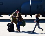 A U.S. Air Force member is greeted by his two children