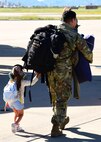 A U.S. Air Force member and his daughter walk while holding hands