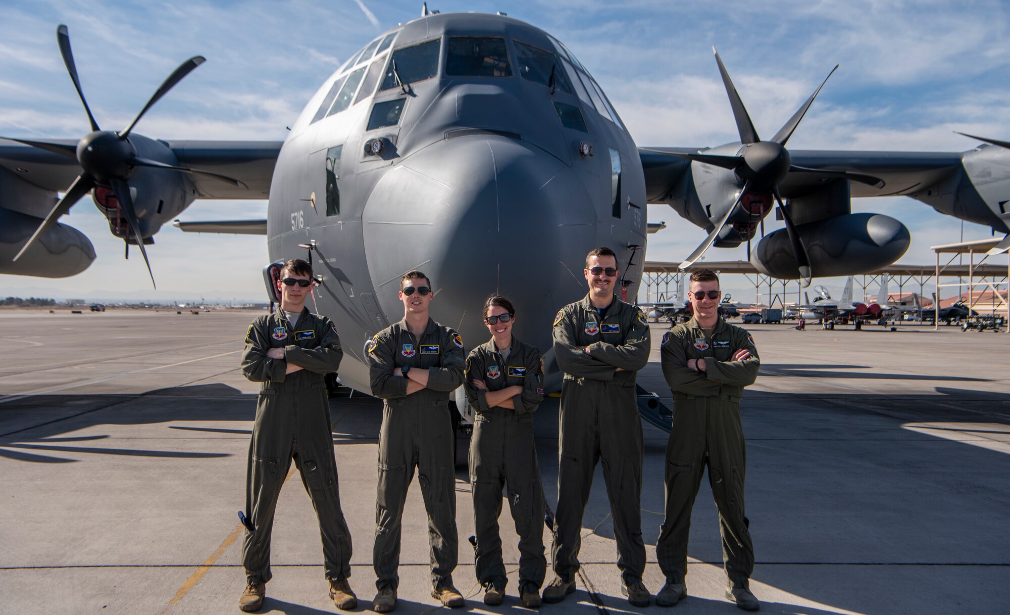 Five Airmen stand in front of aircraft.