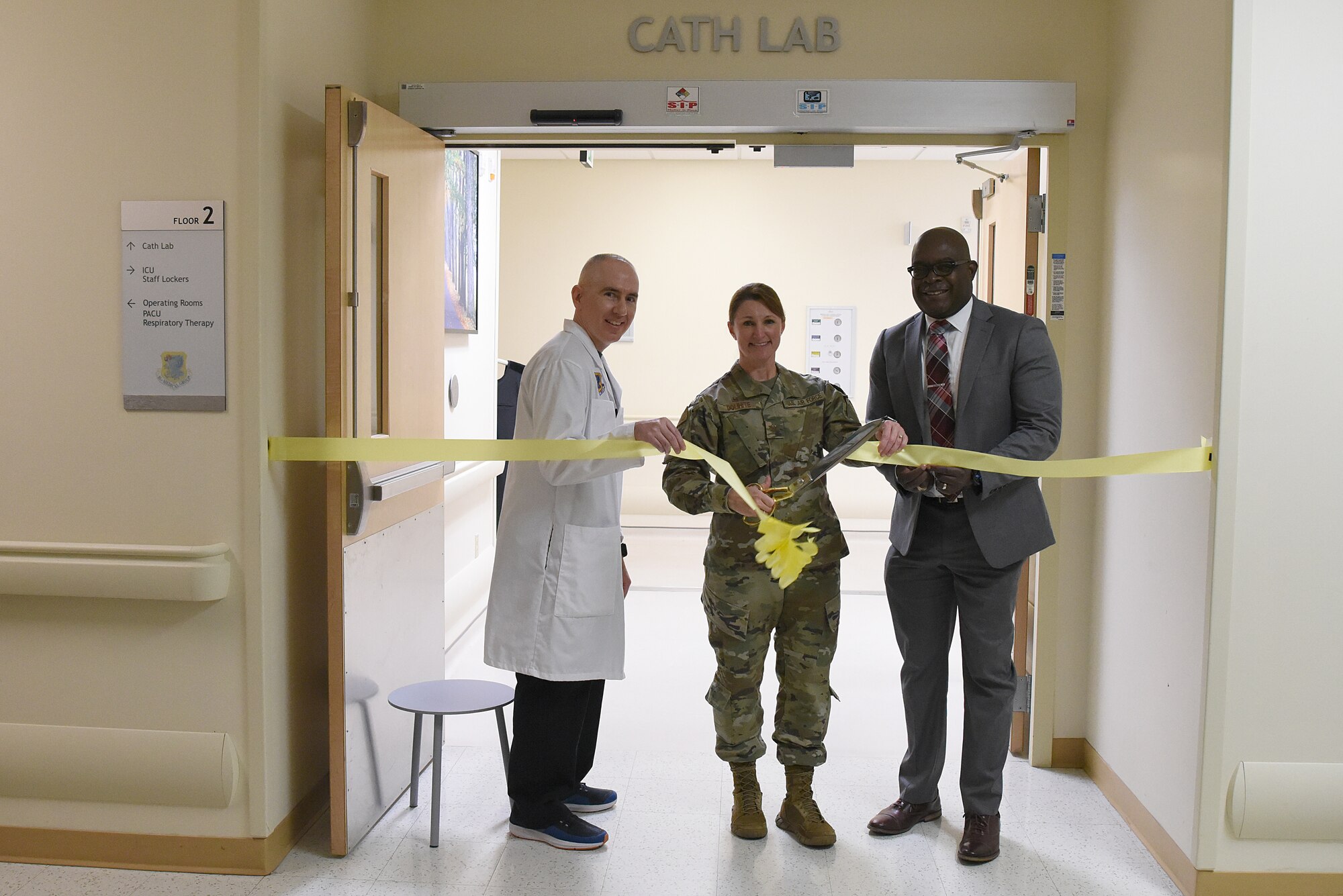 Gilberto Patino, 81st Medical Operations Squadron interventional cardiologist, U.S. Air Force Col. Beatrice Dolihite, 81st Medical Group commander, and Bryan Matthews, Gulf Coast Veterans Healthcare System director, cut a ribbon during the cardiac catheterization laboratory ribbon cutting ceremony inside Keesler Medical Center at Keesler Air Force Base, Mississippi, Nov. 15, 2019. The lab was upgraded with an entire suite of technology to provide better and safer care for patients and the surgical team. (U.S. Air Force photo by Senior Airman Suzie Plotnikov)