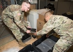 Army Staff Sgt. Marvin Tyler Nelson and Sgt. 1st Class Eugenio Moya, U.S. Army North, pack computers for transport to Wilkinson County High School in Woodville, Mississippi. The computers are being donated to the school through the Department of Defense’s Computers for Learning program.