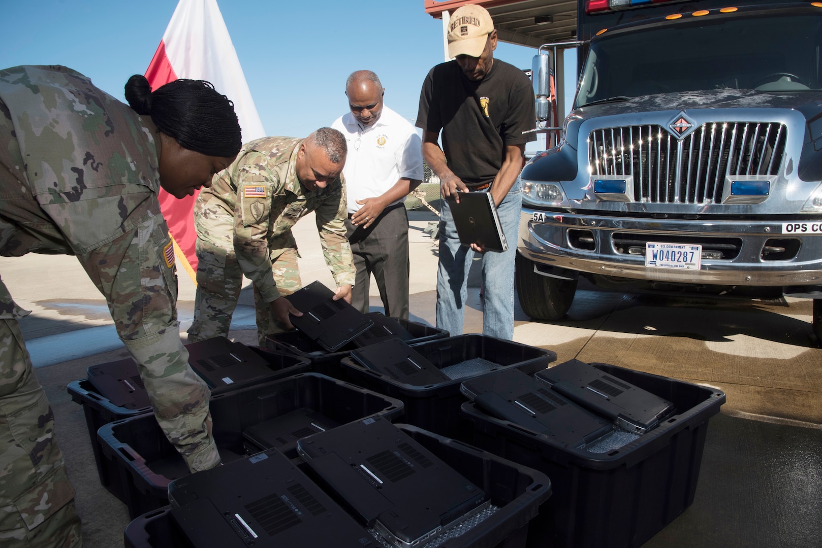 (From left) Army Maj. Kysea Chestnut, information technology deputy division chief and project manager for the Computers for Learning program at U.S. Army North, and Col. Laroy Peyton, U.S. Army North communications director, prepare computers for transport by retired Army Lt. Col. Glen Sutton, the senior Junior Reserve Officer Training Corps instructor at Wilkinson County High School in Woodville, Mississippi, and retired U.S. Army Sgt. 1st Class Howard Baity, Army JROTC instructor at Wilkinson County High School.