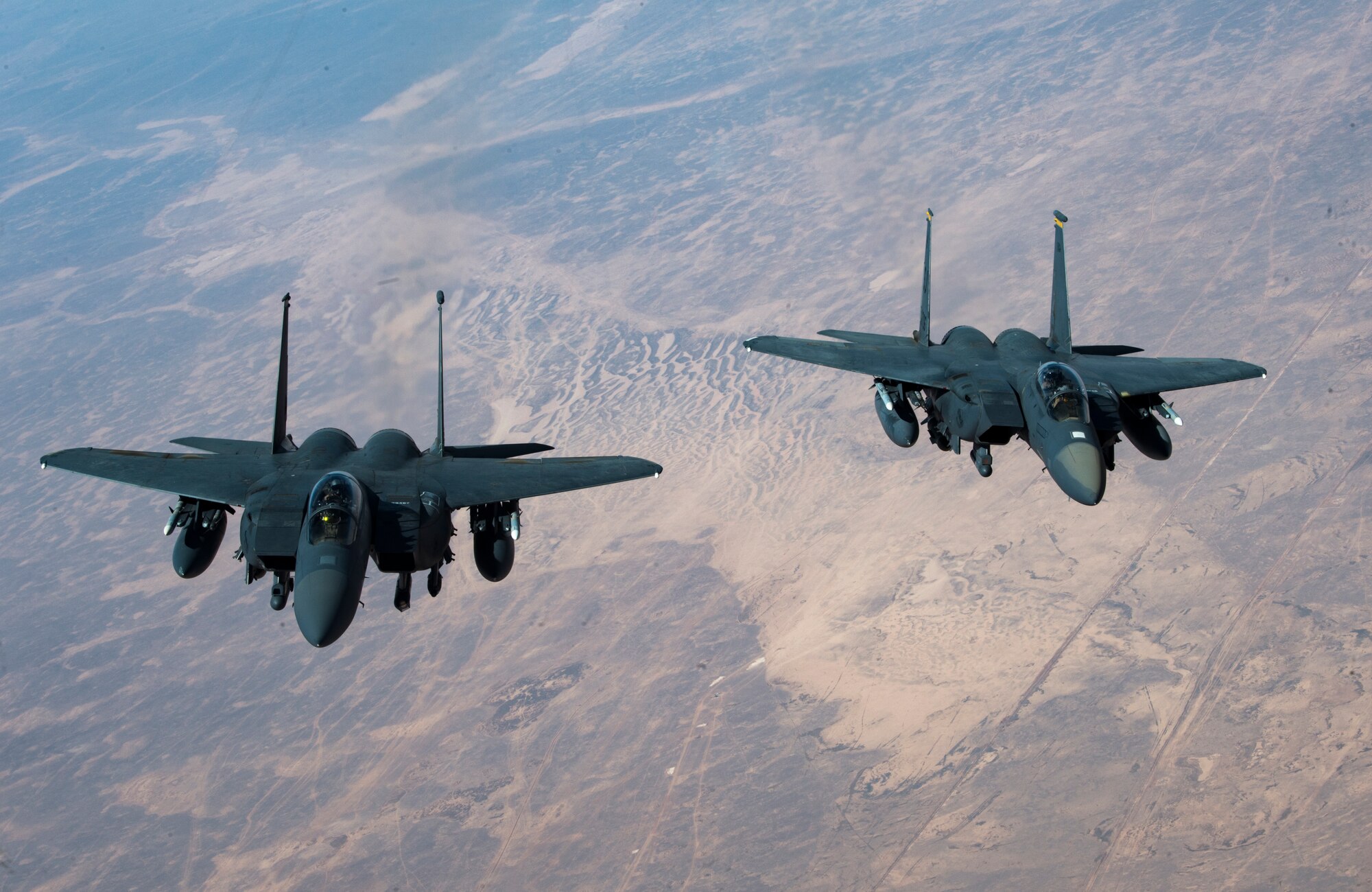 Two U.S. Air Force F-15 Strike Eagles fly in formation after receiving fuel from a KC-135 Stratotanker assigned to the 28th Expeditionary Air Refueling Squadron, Al Udeid Air Base, Qatar, above an undisclosed location, Oct. 10, 2019.