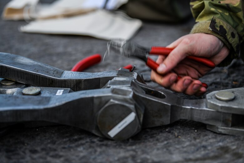 U.S. Airmen from the 31st Maintenance Squadron place a pin into a lifting sling at Aviano Air Base, Italy, Nov. 16, 2019. The 31st Maintenance Squadron provides accessory maintenance, avionics, periodic phase inspections, fabrication, and aerospace ground equipment for 50 assigned aircraft. (U.S. Air Force photo by Airman 1st Class Ericka A. Woolever).