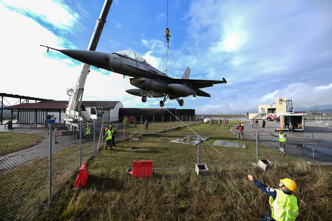 U.S. Airmen from the 31st Maintenance Squadron rotate an F-16 Fighting Falcon as it lifts from the ground at Aviano Air Base, Italy, Nov. 16, 2019. The purpose of a real-world crashed damaged disabled aircraft recovery is to clear the runway as safely and quickly as possible while causing no further damage to the aircraft. (U.S. Air Force photo by Airman 1st Class Ericka A. Woolever).