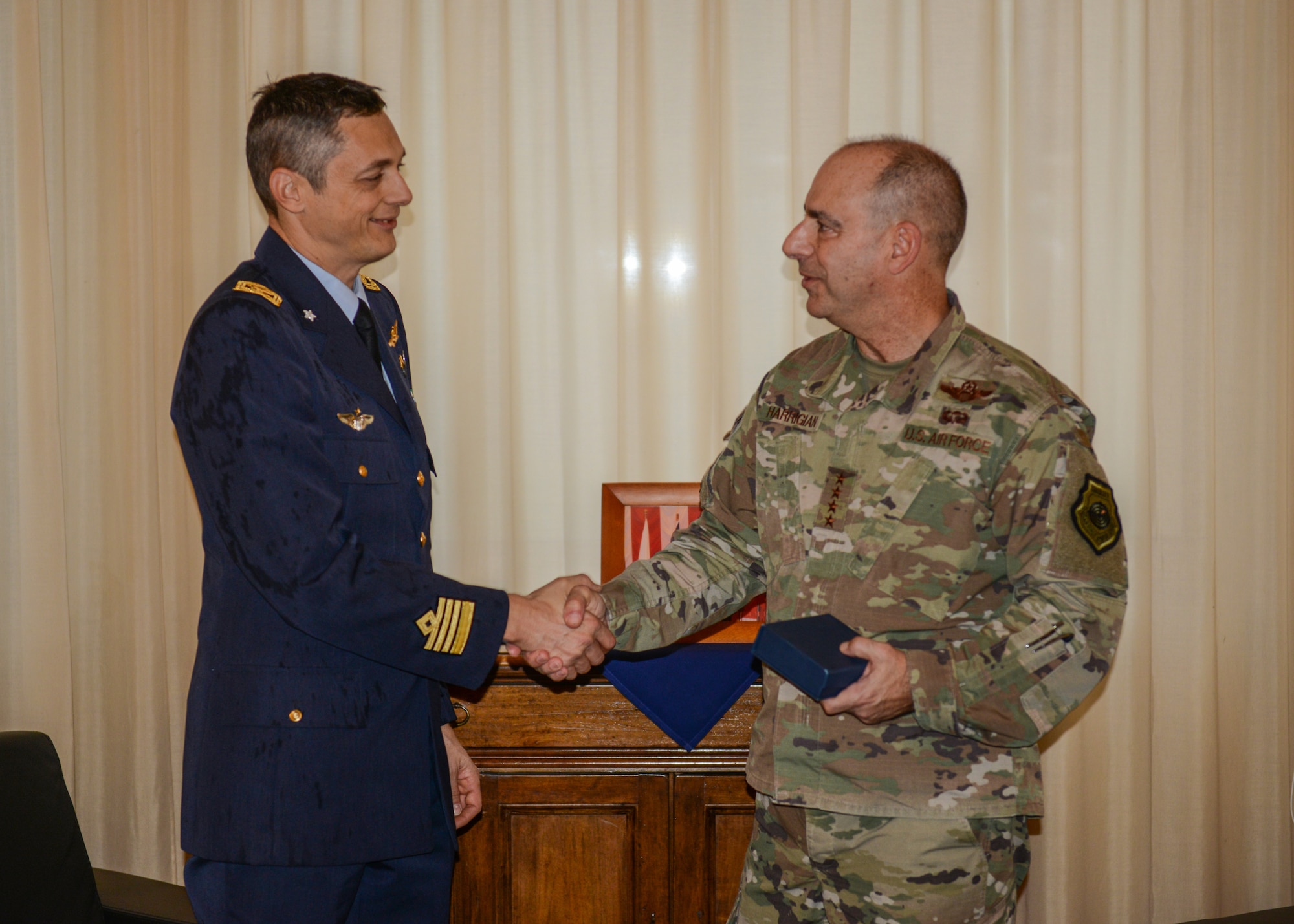 U.S. Air Force Gen. Jeffrey L. Harrigian, U.S. Air Forces in Europe and Air Forces Africa commander (right), shakes hands with Italian Air Force Col. Luca Crovatti, ITAF base commander (left) at Aviano Air Base, Italy, Nov. 15, 2019. Gen. Harrigian is a command pilot with more than 4,100 hours in the F-22, F-15C, A/OA-37 and MQ-1 aircraft. (U.S. Air Force photo by Airman Thomas S. Keisler IV)
