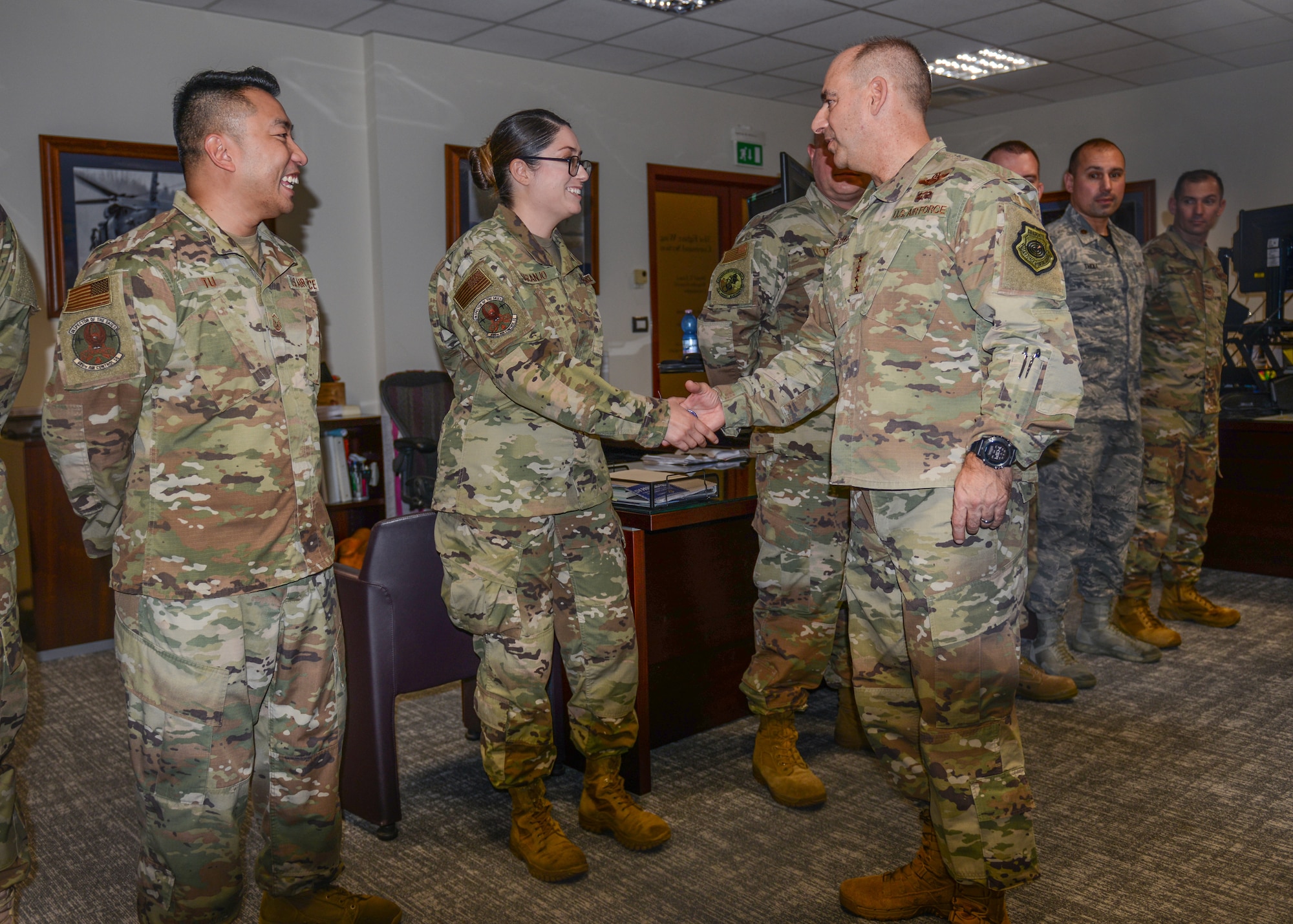 U.S. Air Force Gen. Jeffrey L. Harrigian, U.S. Air Forces in Europe and Air Forces Africa commander, coins U.S. Air Force Airman 1st Class Maria G. Naranjo, 606 Air Control Squadron tactical data link system technician, at Aviano Air Base, Italy, Nov. 15, 2019. The challenge coin tradition began in World War I and exhibits commendable service, a lively legacy and supports unit morale across the Air Force. (U.S. Air Force photo by Airman Thomas S. Keisler IV)