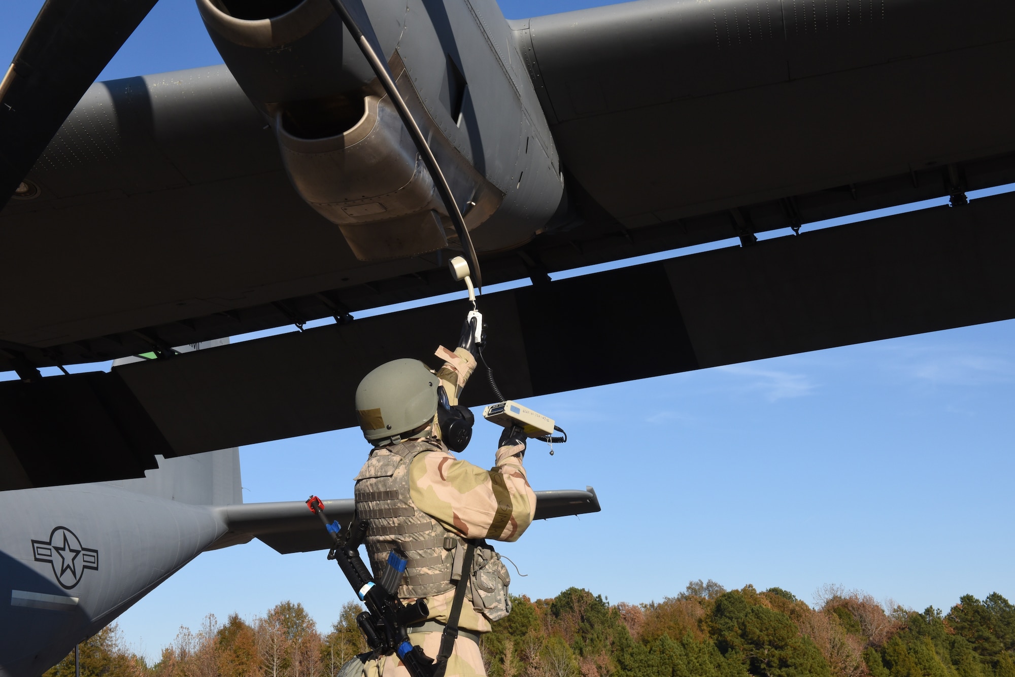 An Airman scans a plane for radiation