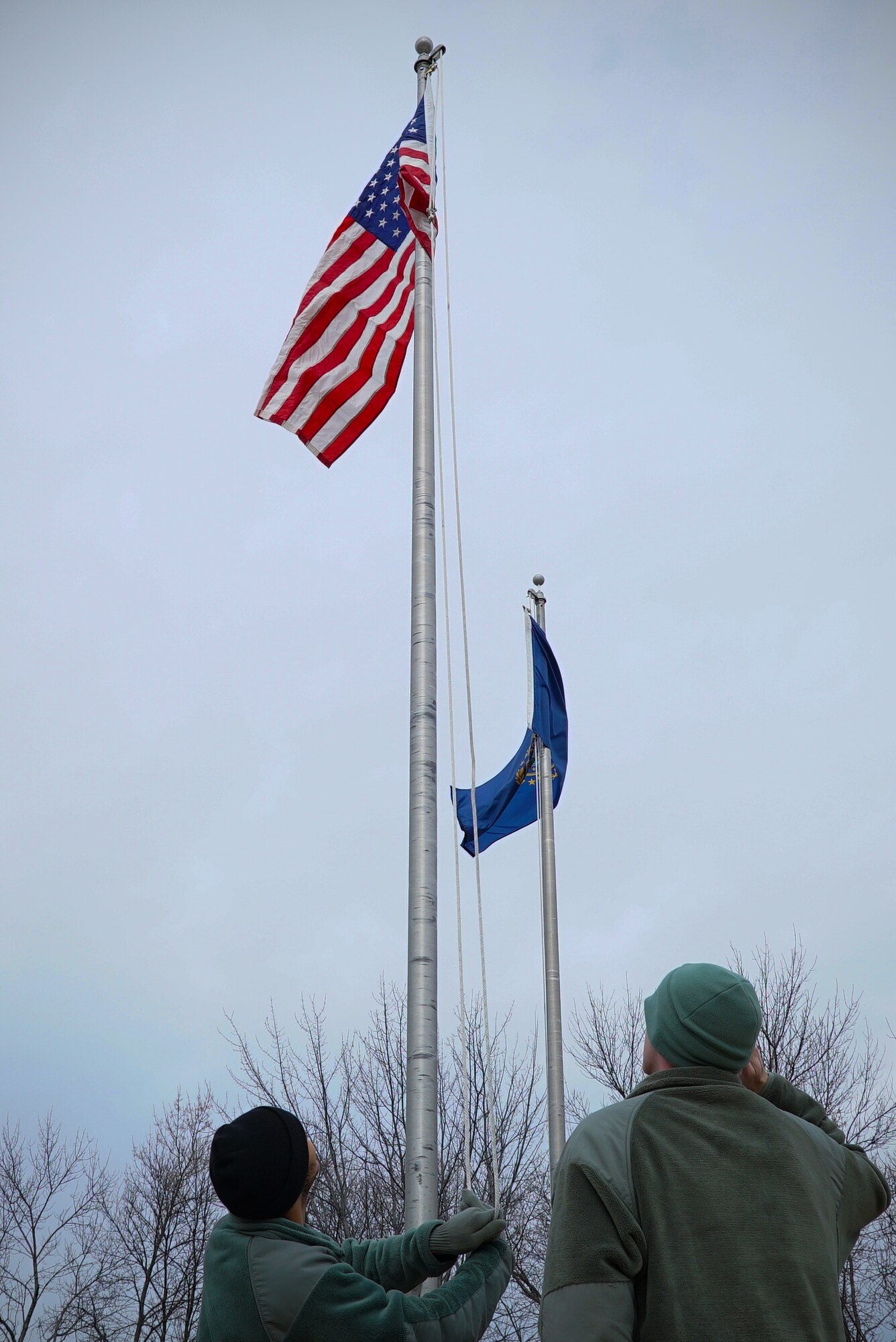 Airmen with the 348th Reconnaissance Squadron raise and salute a United States flag Nov. 8, 2019, on Grand Forks Air Force Base, North Dakota. All state flags at the installation entrance were lowered and switched to U.S. flags by the 348 RS for Veterans Day. (U.S. Air Force photo by Senior Airman Elora J. Martinez)
