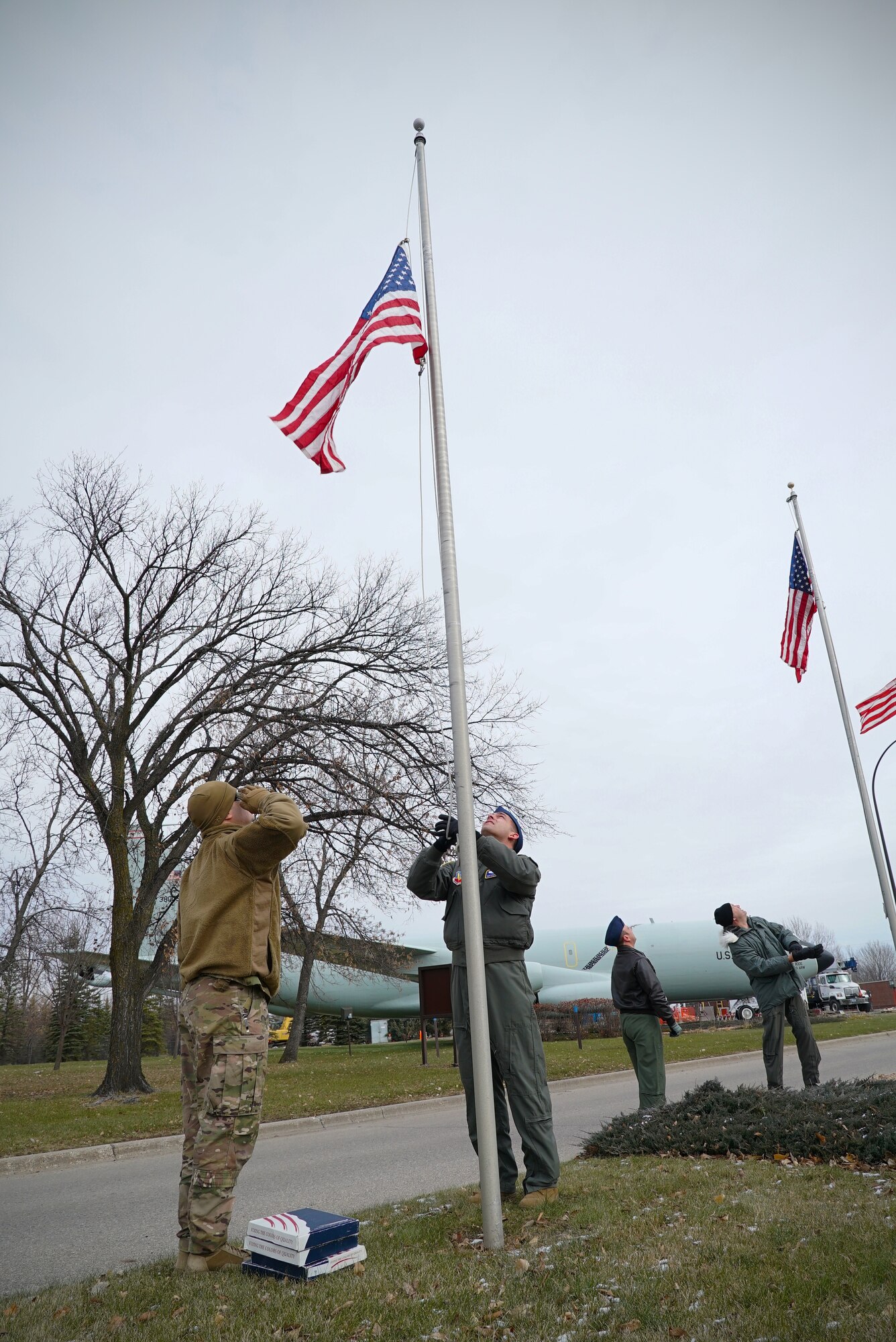 Airmen with the 348th Reconnaissance Squadron raise and salute a United States flag Nov. 8, 2019, on Grand Forks Air Force Base, North Dakota. The 348 RS worked in teams of two to lower and remove state flags in order to raise U.S. flags for Veterans Day. (U.S. Air Force photo by Senior Airman Elora J. Martinez)