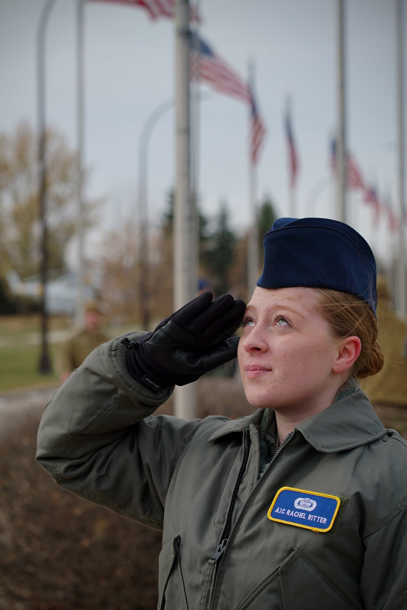 Airman 1st Class Rachel Ritter, 348th Reconnaissance Squadron analyst, salutes as a United States flag is raised Nov. 8, 2019, on Grand Forks Air Force Base, North Dakota. The 348 RS braved sub-freezing temperatures to remove all state flags from the installation’s avenue of flags and replace them with U.S. flags for Veterans Day. (U.S. Air Force photo by Senior Airman Elora J. Martinez)