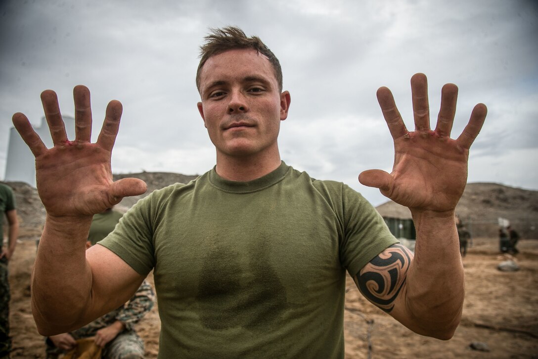U.S. Marine Corps Sgt. Jacob Wright, motor vehicle operator assigned to Special Purpose Marine Air-Ground Task Force Crisis Response-Central Command 19.1, shows blisters sustained from utilizing an entrenching tool (E-tool) to dig trenches for burying wire during Talon Exercise 1-19 at Marine Corps Air Station Yuma, Arizona, Sept. 30, 2018. TALONEX is a pre-deployment training event that integrates elements of the SPMAGTF and tests their capabilities when faced with simulated scenarios. Marines took precautions such as digging trenches and filling sandbags in preparation of inclement weather that was sustained during the exercise.