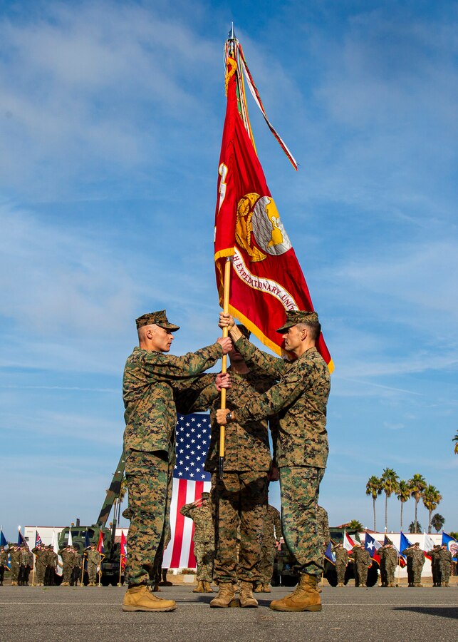 U.S. Marine Corps Col. Jay M. Holtermann, right, the 15th Marine Expeditionary Unit outgoing commanding officer, passes the colors to Col. Christopher J. Bronzi, incoming commanding officer, during a change of command ceremony at Marine Corps Base Camp Pendleton, California, Nov. 13, 2019. A change of command is a military tradition that represents a formal transfer of authority from one commanding officer to another. (U.S. Marine Corps photo by Lance Cpl. Mackenzie Binion)