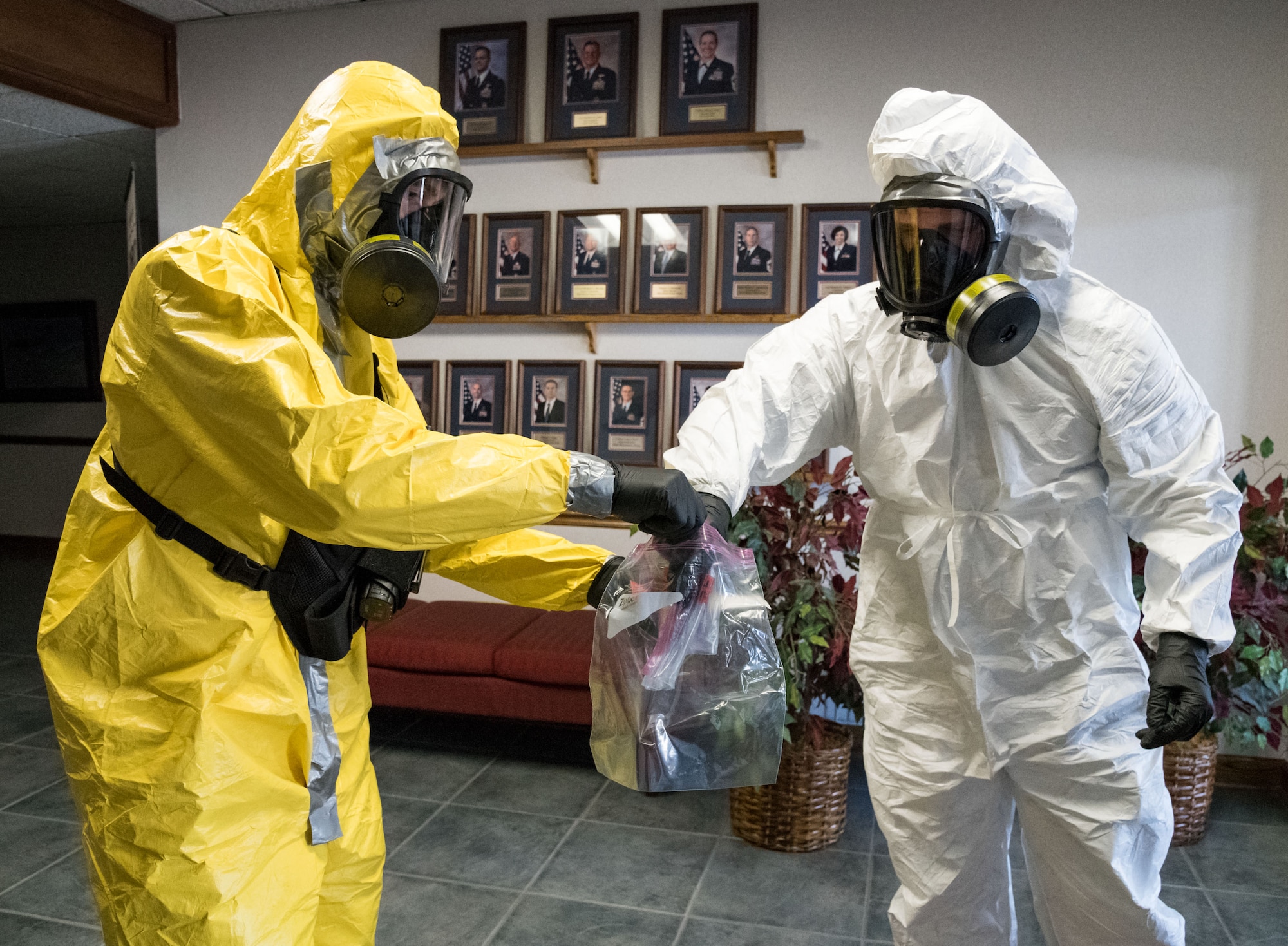 Airman 1st Class Owen Laroche, 436th Civil Engineer Squadron, places a suspicious substance into a plastic bag held by Senior Airman Taylor Werth, 436th CES, during Exercise DORMAR Nov. 13, 2019, on Dover Air Force Base, Del. Laroche and Werth, both emergency management journeymen, worked as a team to safely remove the simulated Fentanyl from the wing headquarters building. (U.S. Air Force photo by Roland Balik)