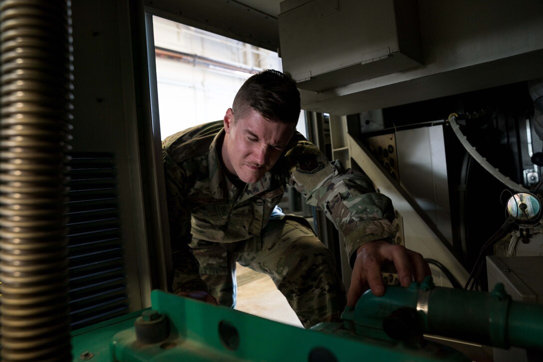 Senior Airman Justin Harrison, 90th Missile Maintenance Squadron, Facility Maintenance Section, support section supervisor, hits his head while performing maintenance on a portable air condition unit on F.E. Warren AFB, Wyoming, Nov. 18, 2019. Tech. Sgt. Haisen Exon, 90 MMXS/FMS, support section NCOIC, teams up with the 90th Missile Wing LaunchWerx agency to bring forward an idea to prevent future head injuries across the wing. (U.S. Air Force photo by Joseph Coslett)